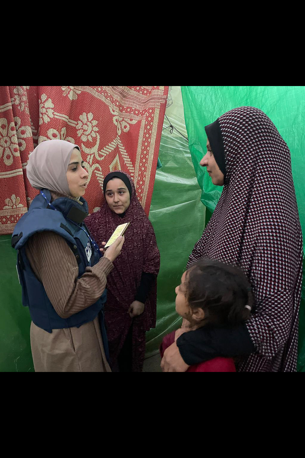 Maram Humaid interviews displaced people in a camp in Deir el-Balah, Gaza, during Israel's war on the enclave