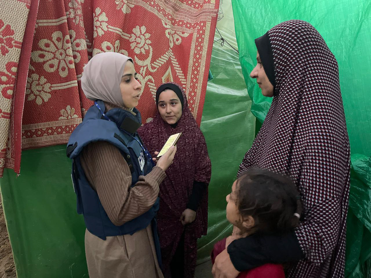 Maram Humaid interviews displaced people in a camp in Deir el-Balah, Gaza, during Israel's war on the enclave