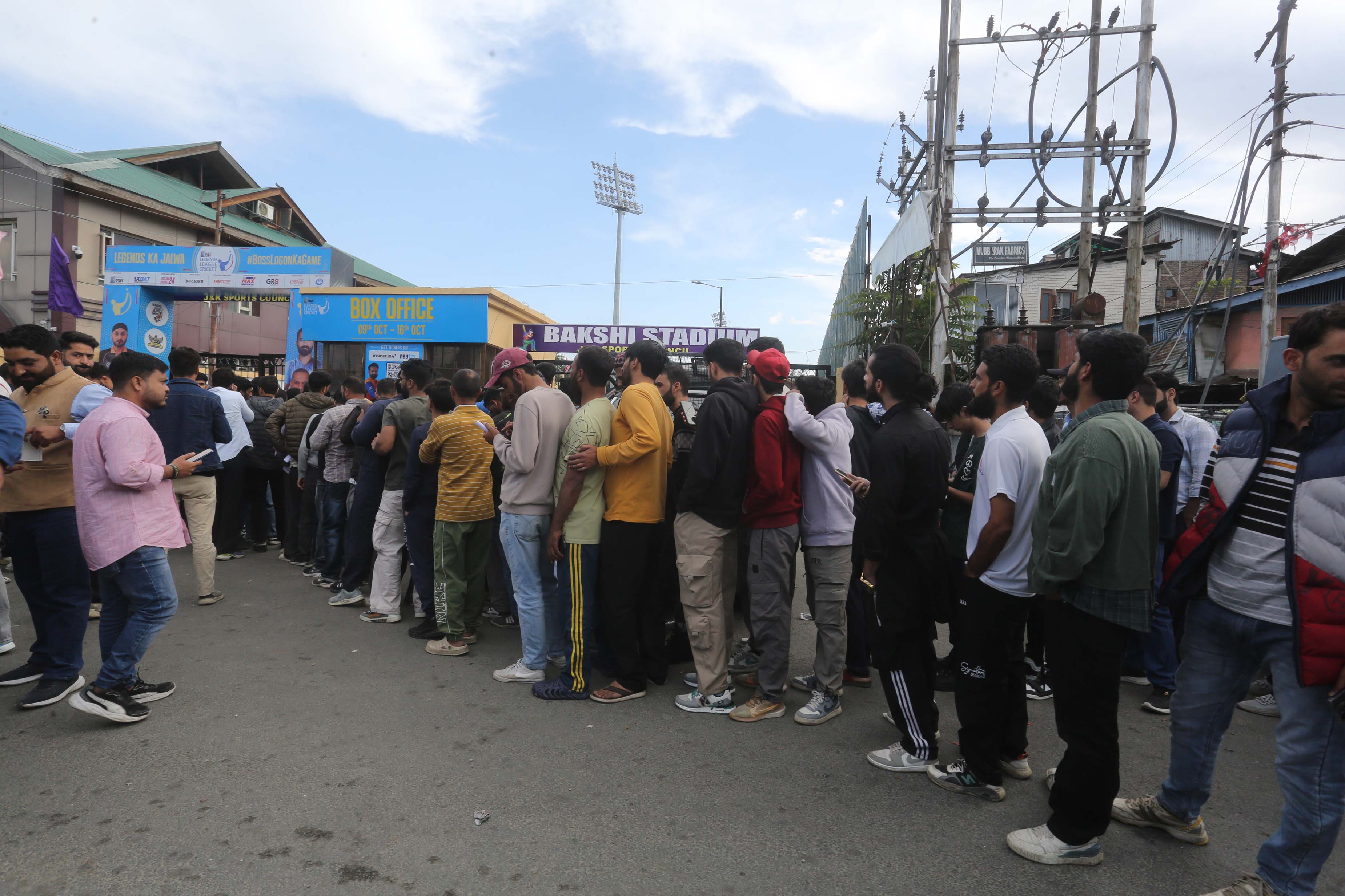 People queue outside a ticketing counter in Bakshi Stadium in the main city of Srinagar in Indian-administered Kashmir where Legends League Cricket matches are being held. [Shuaib Bashir/Al Jazeera]