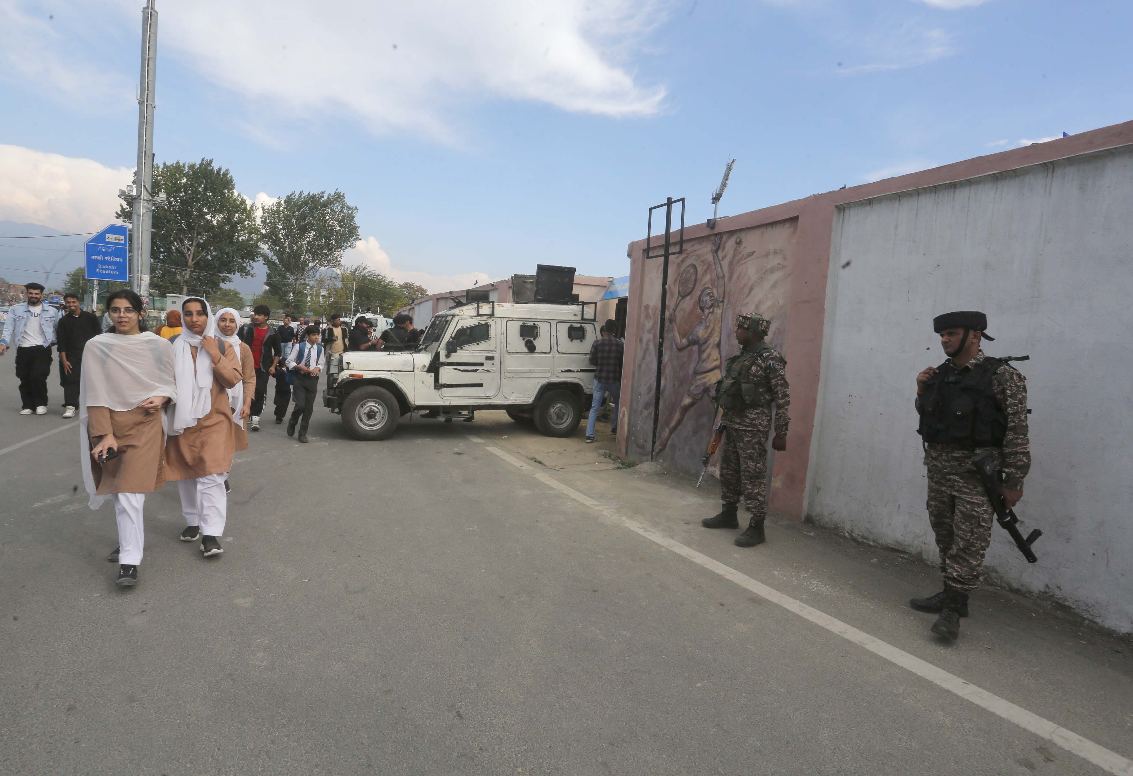 Students walk towards the venue of the LLC tournament in the main city of Srinagar in Indian-administered Kashmir where the matches are being held under high-security watch and surveillance. [Shuaib Bashir/Al Jazeera]