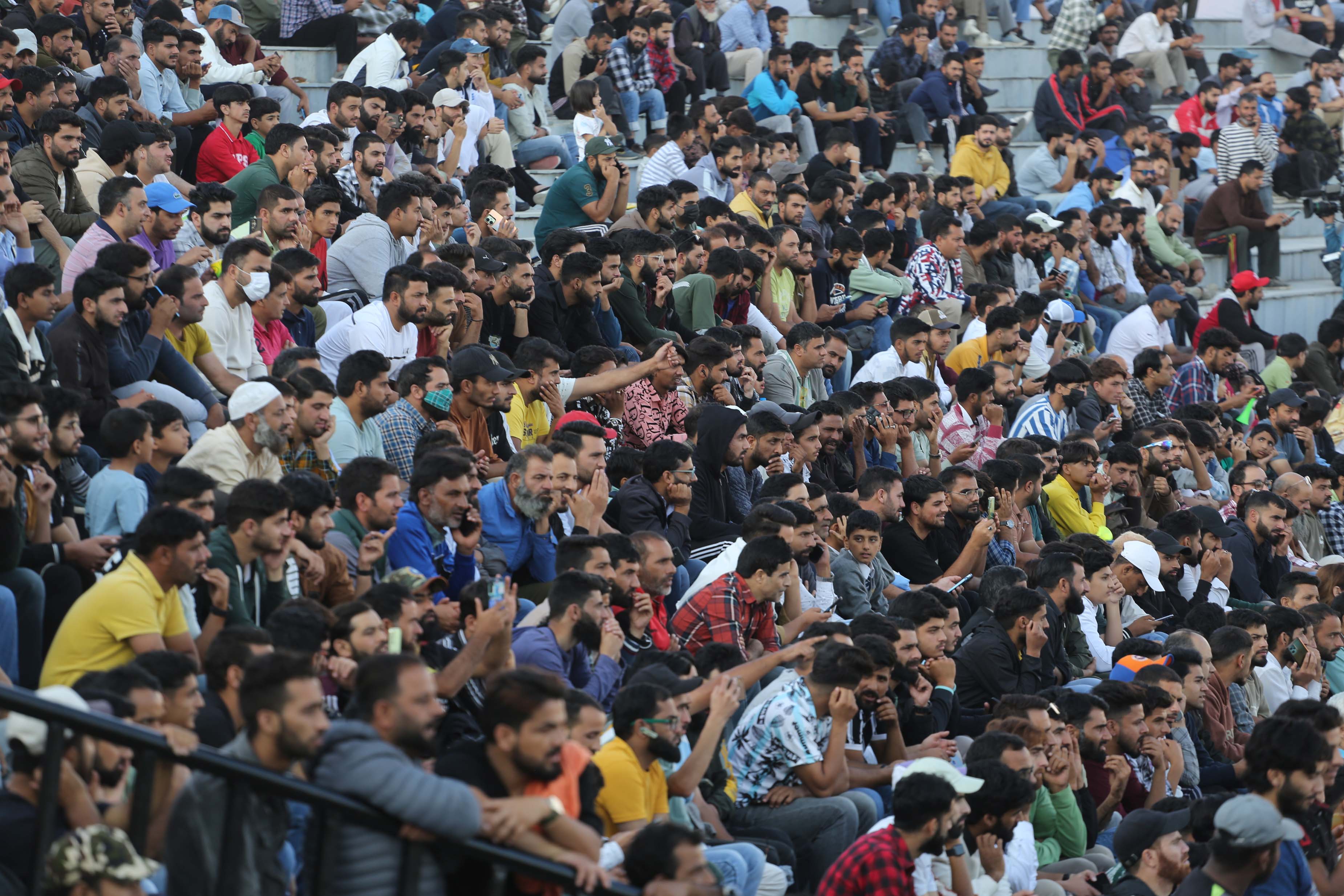 People watching the cricket match inside Bakshi Stadium in the main city of Srinagar, where thousands of fans flocked to watch the retired international cricketers playing in the home city. [Shuaib Bashir/Al Jazeera]