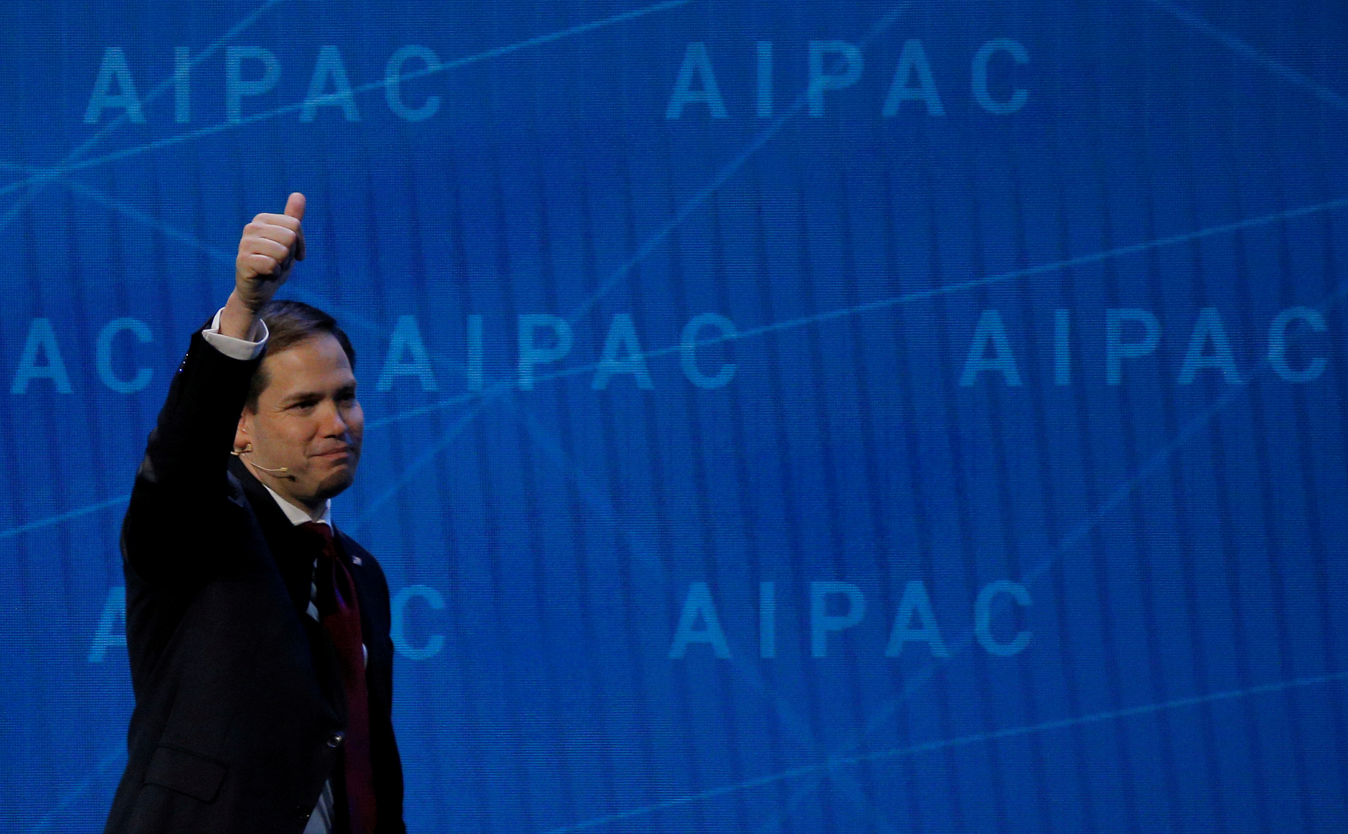 a man walks in front of a blue wall that says apace