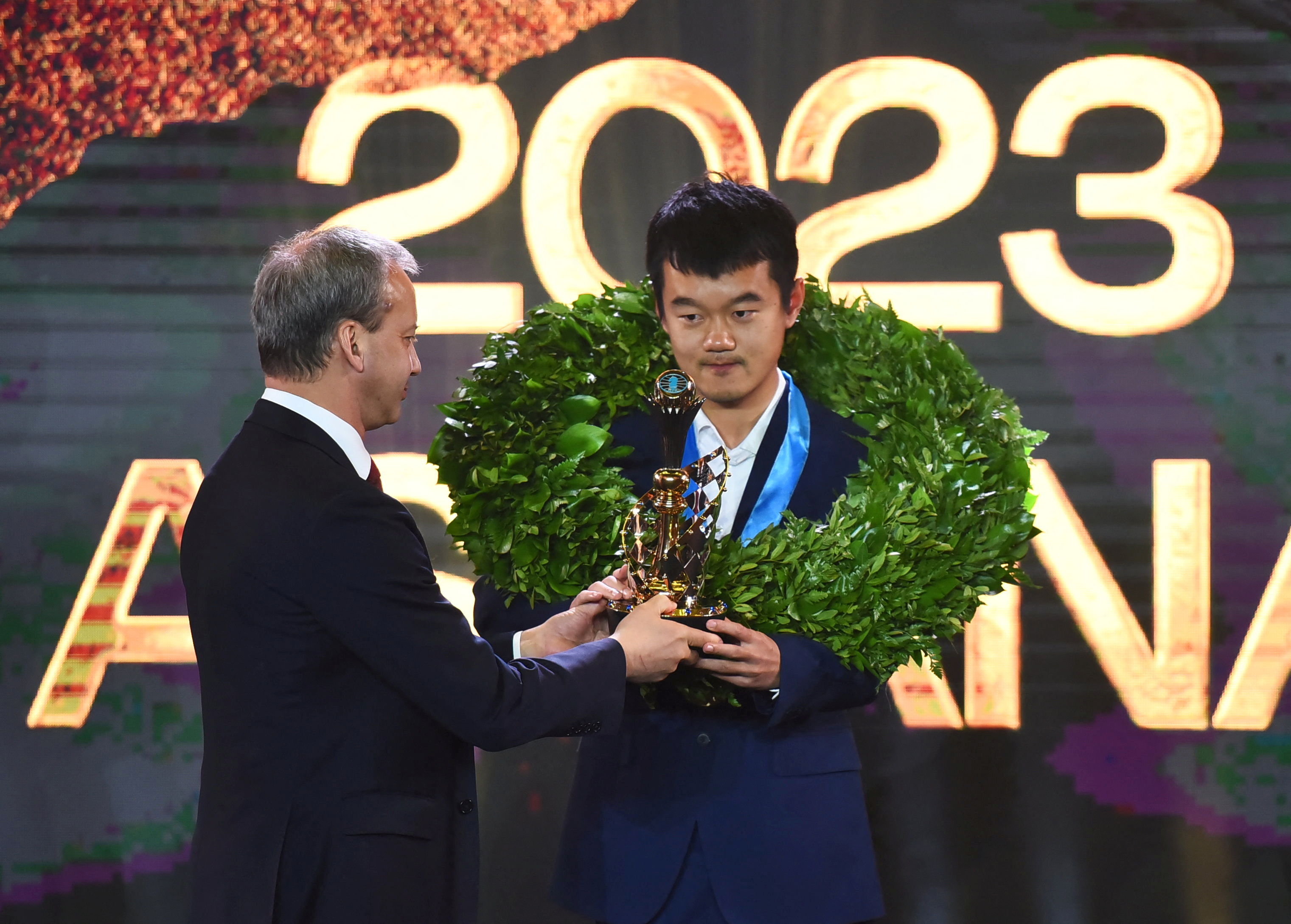 Chess - FIDE World Championship Match 2023 - Closing Ceremony - Astana, Kazakhstan - May 1, 2023. Ding Liren of China receives his trophy from FIDE President Arkady Dvorkovich during the closing ceremony. REUTERS/Vladislav Vodnev