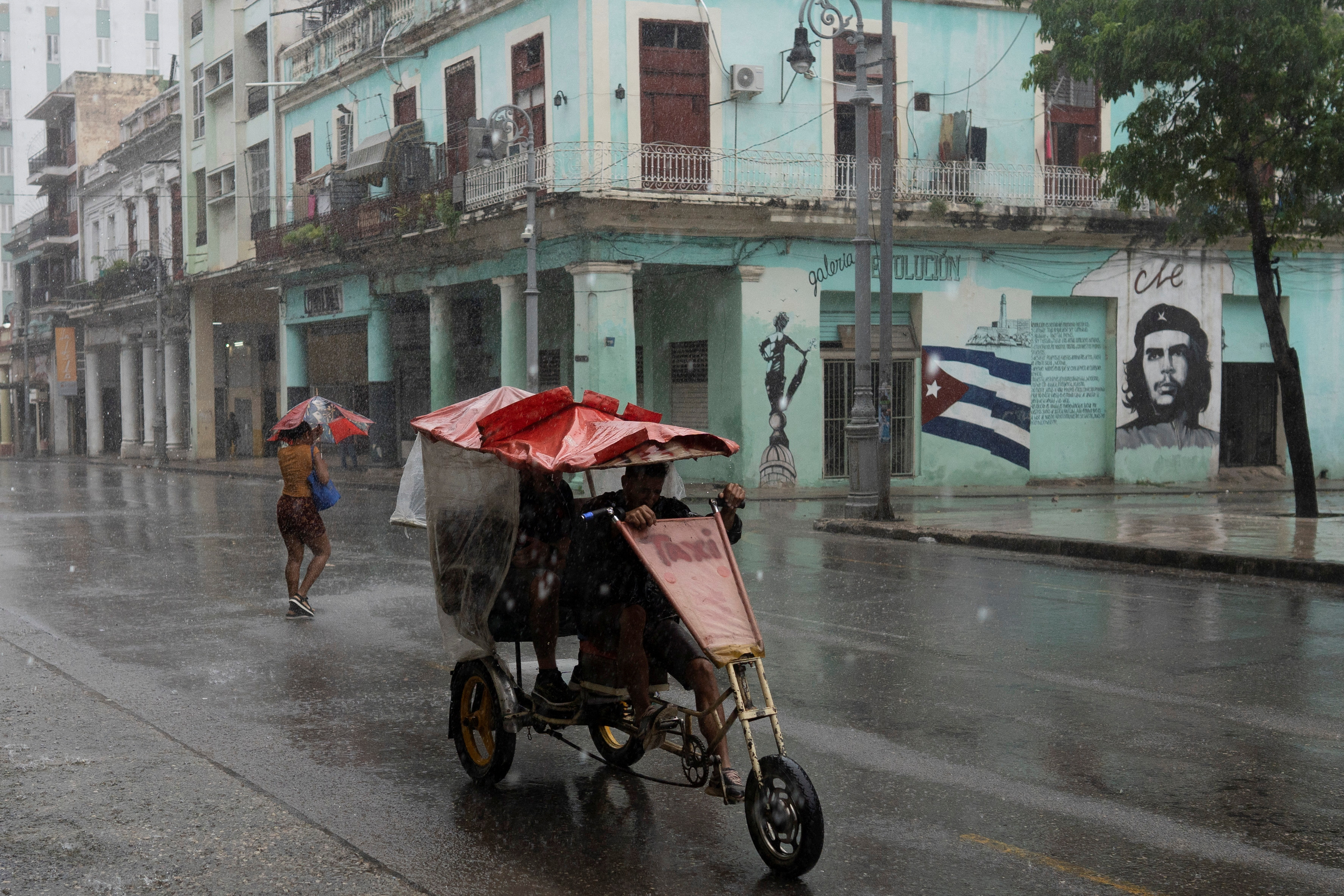People pass by on the street as Hurricane Rafael passes by Havana, Cuba, November 6, 2024. [REUTERS/Alexandre Meneghini]