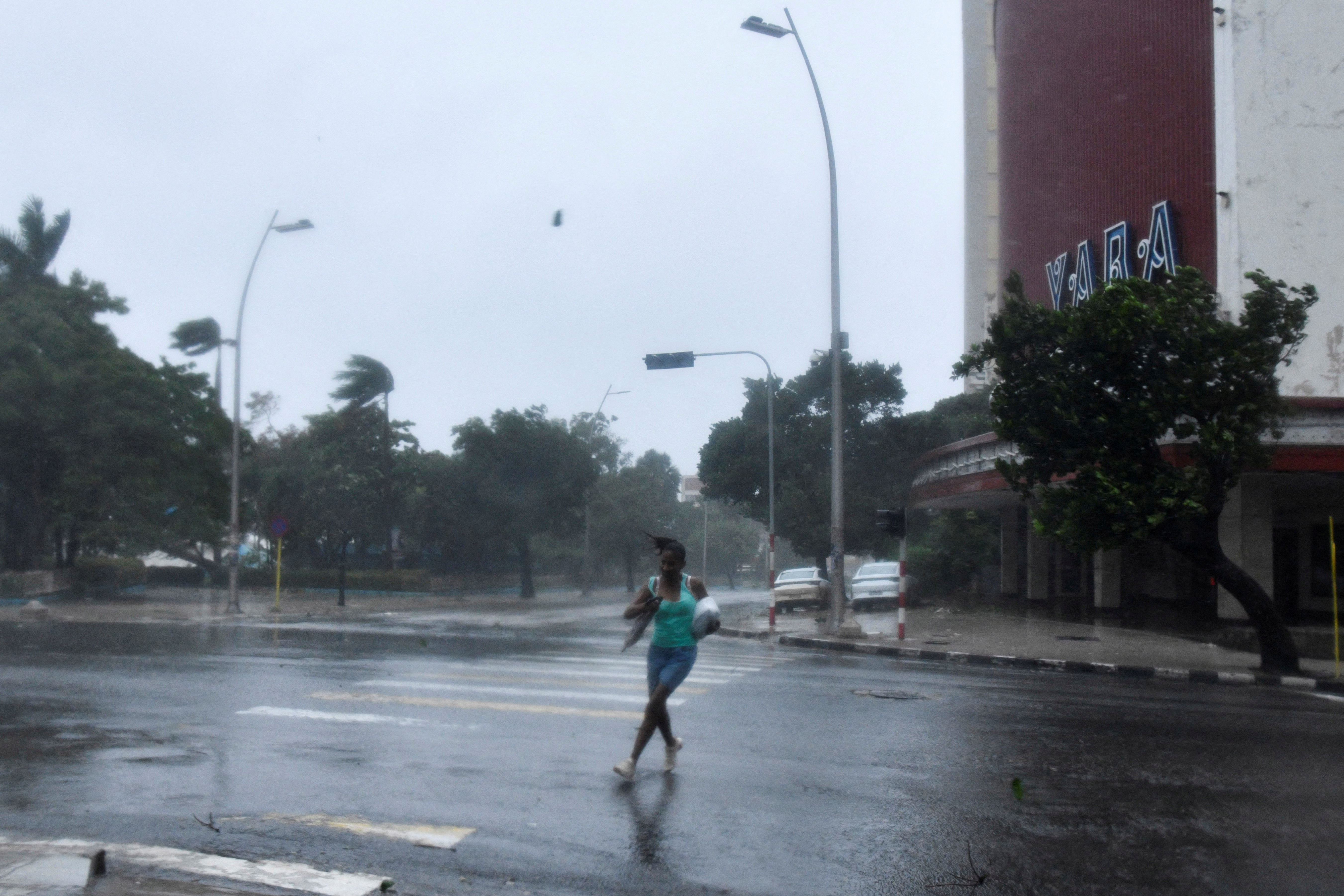 A person walks through an empty street in the rain