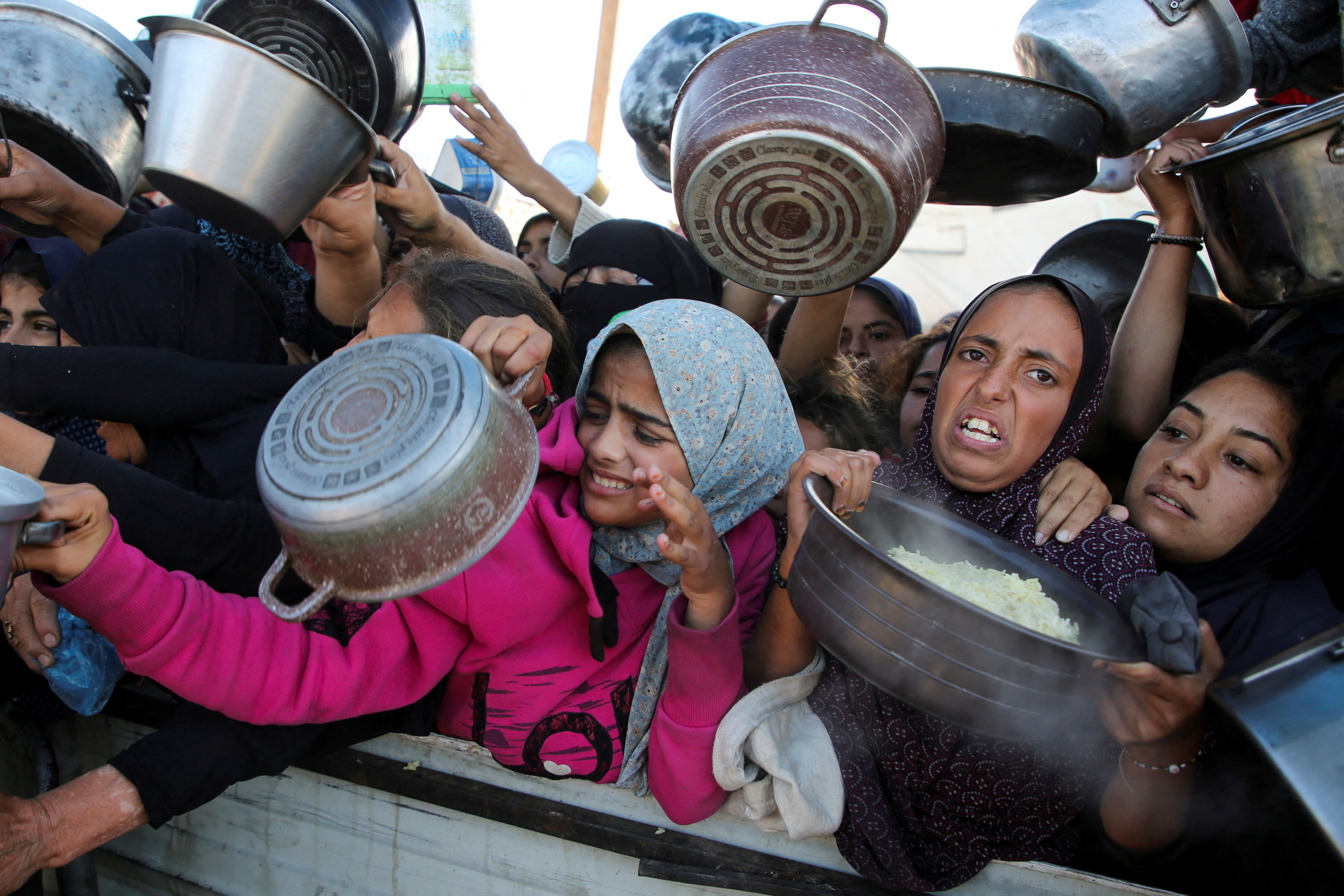 Palestinians gather to receive food cooked by a charity kitchen, amid a hunger crisis, as the Israel-Gaza conflict continues, in Khan Younis in the southern Gaza Strip, November 19, 2024. REUTERS/Hatem Khaled TPX IMAGES OF THE DAY