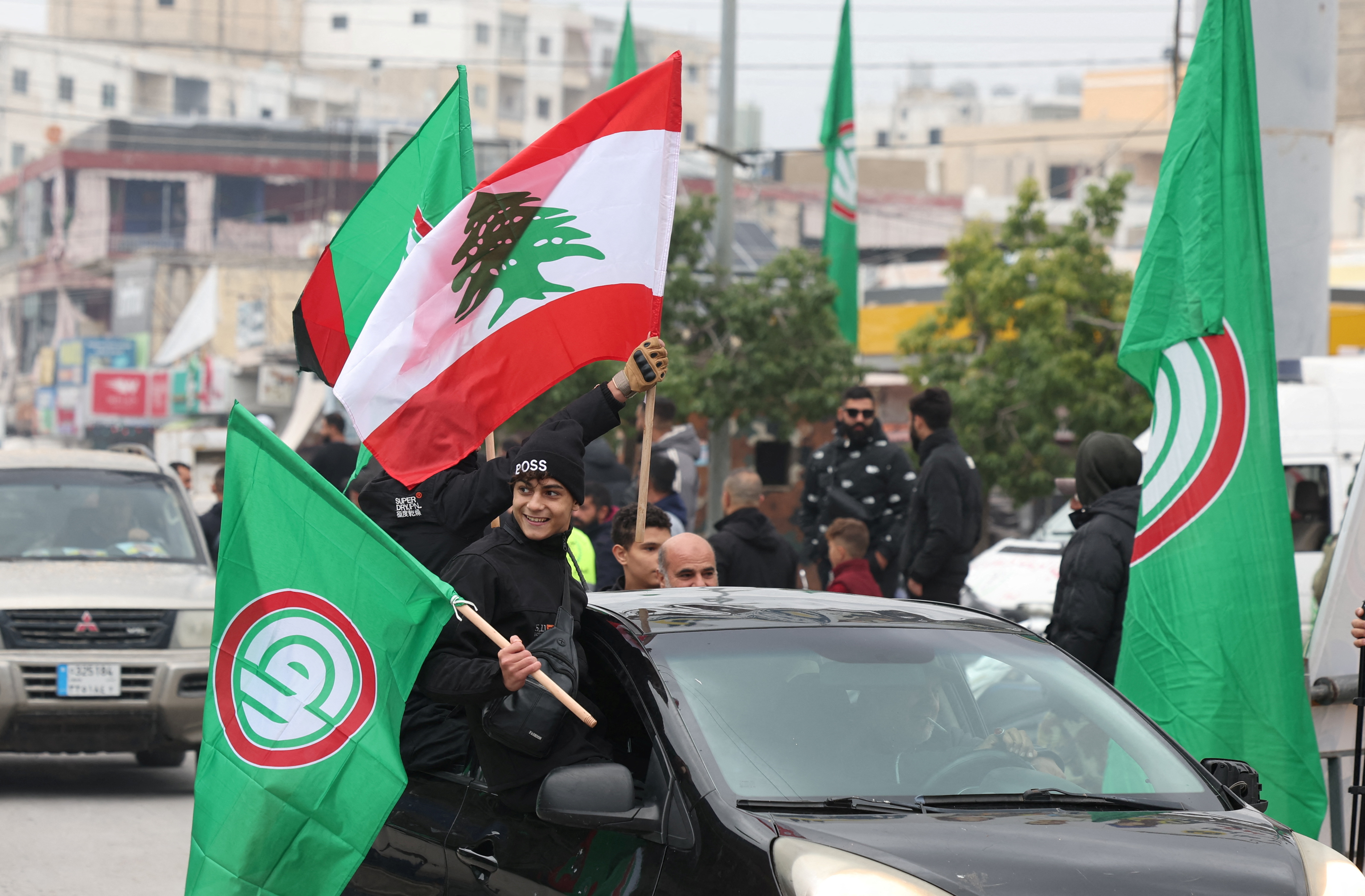 People wave Lebanese and Amal movement flags in Tyre, after a ceasefire between Israel and Iran-backed group Hezbollah took effect at 0200 GMT on Wednesday after U.S. President Joe Biden said both sides accepted an agreement brokered by the United States and France, in Lebanon, November 27, 2024. REUTERS/Aziz Taher