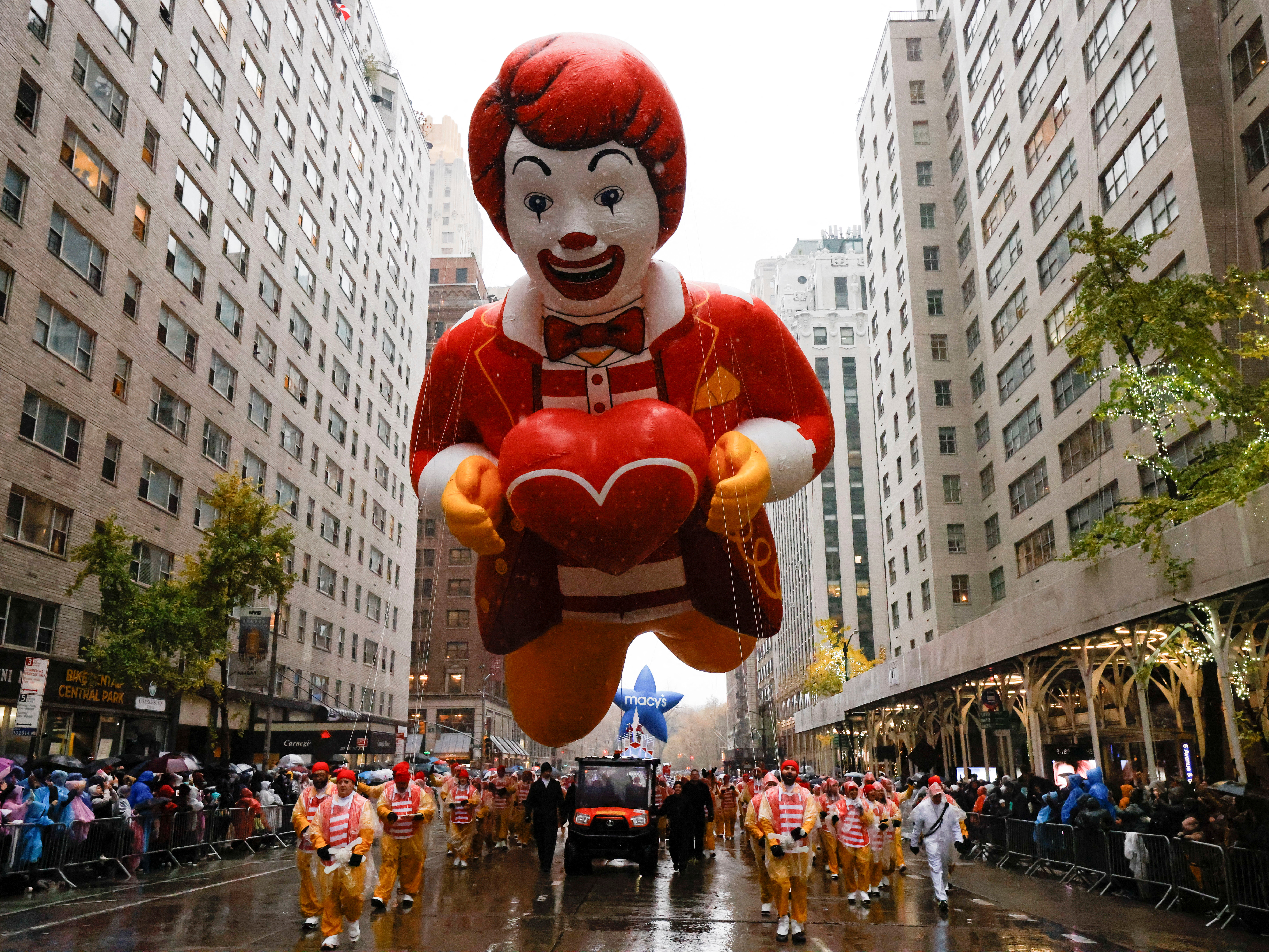 A Ronald McDonald float travels down a central Manhattan street.
