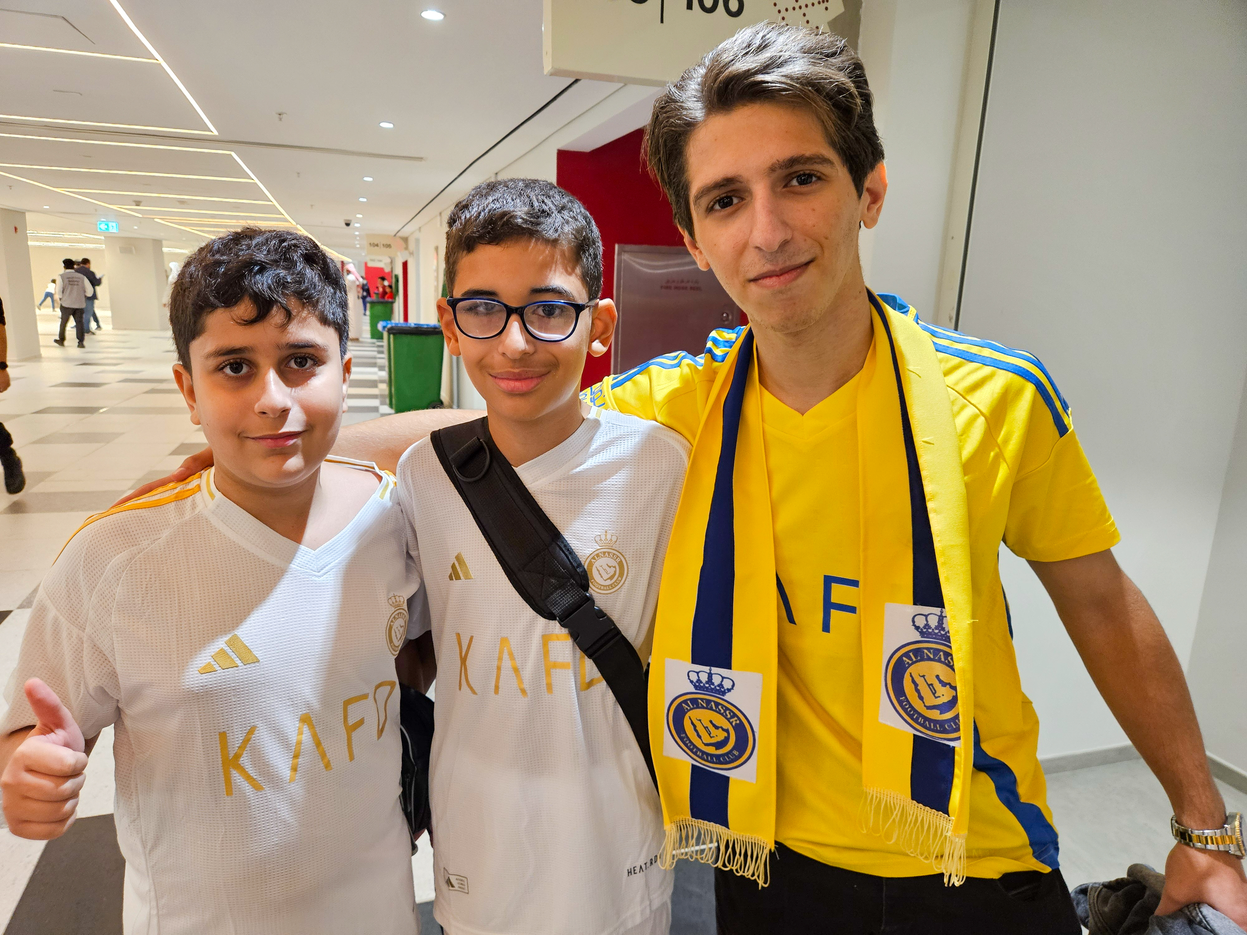 Football fan Abdallah Abdel Razeq (right) and his cousins at the AFC Champions League Elite Group B match between Al Gharafa SC of Qatar and Al Nassr FC at the Al Bayt Stadium in Al Khor, Qatar [Hafsa Adil/Al Jazeera]
