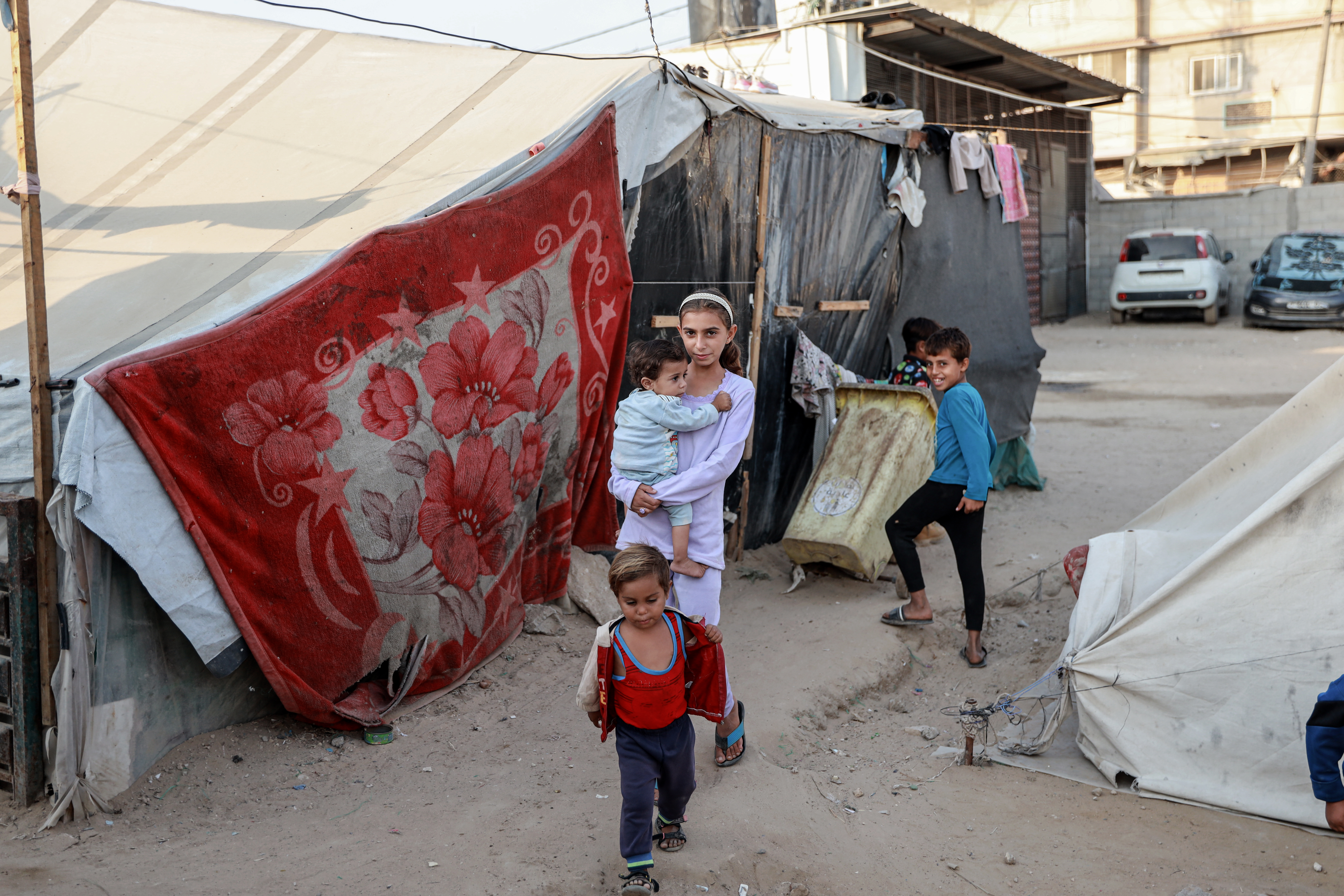 Children walk between tents