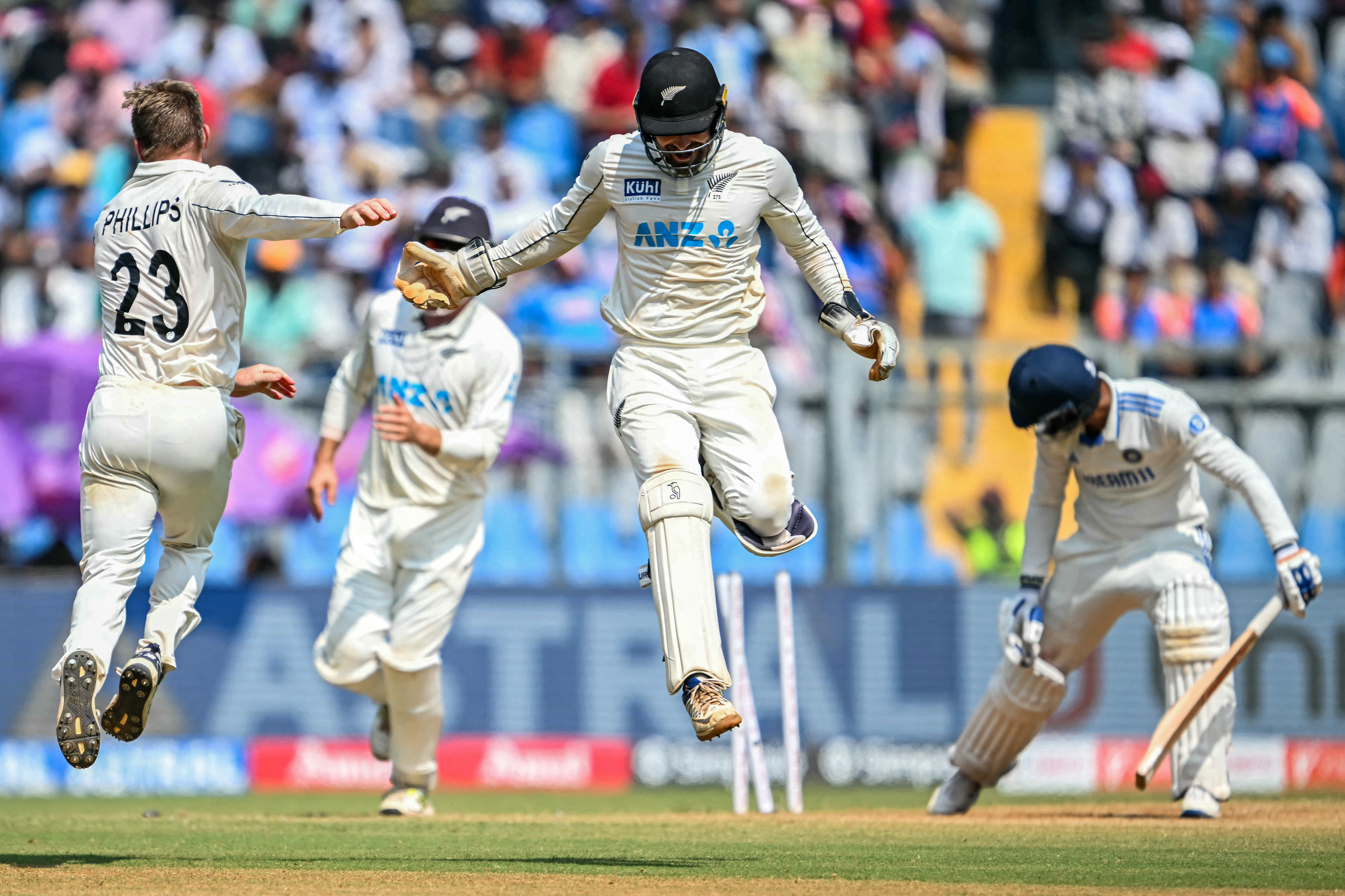New Zealand's Glenn Phillips celebrates with teammate Tom Blundell after taking the wicket of India's Akash Deep