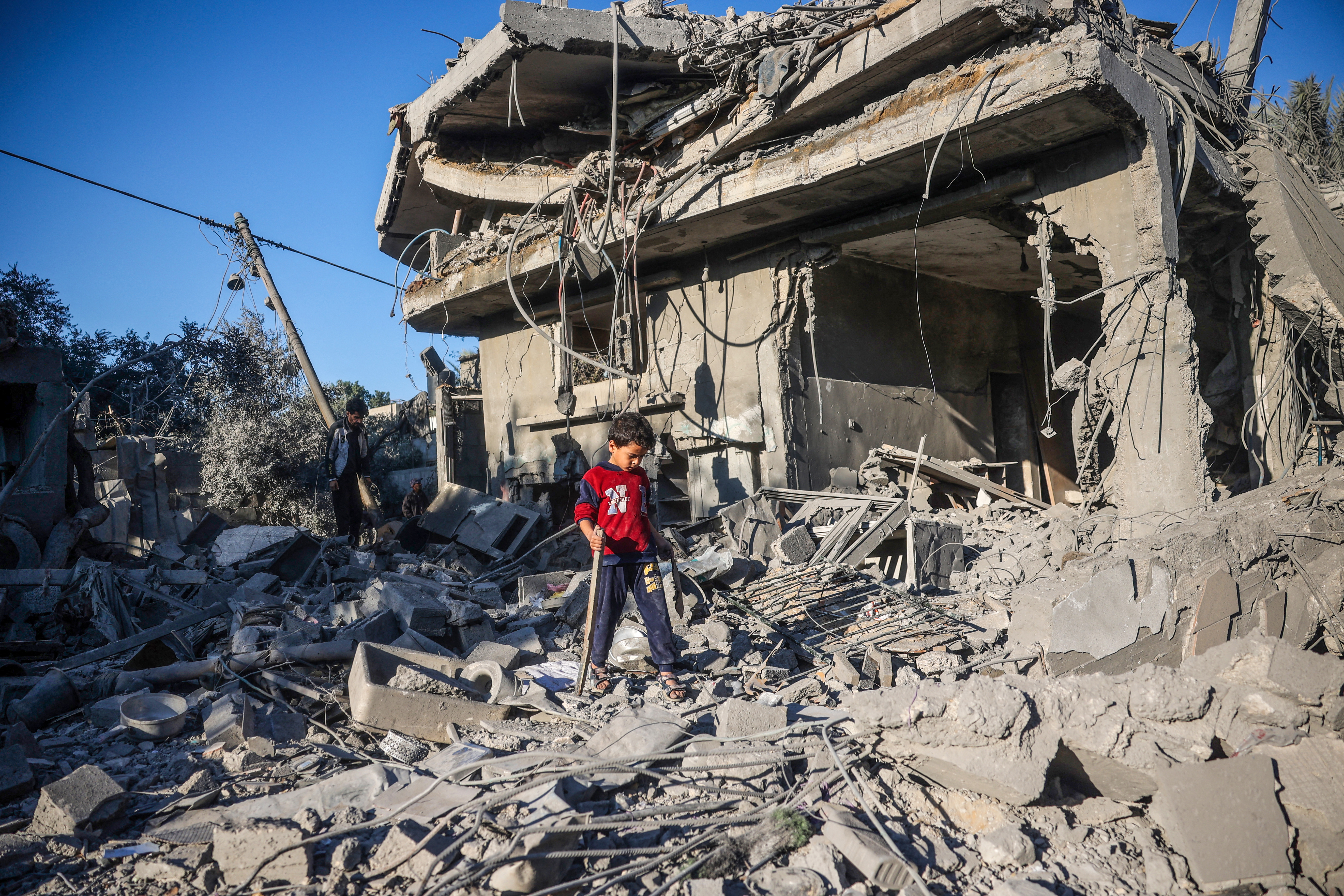 A boy walks on the rubble of a house destroyed in an Israeli strike at the Nuseirat refugee camp