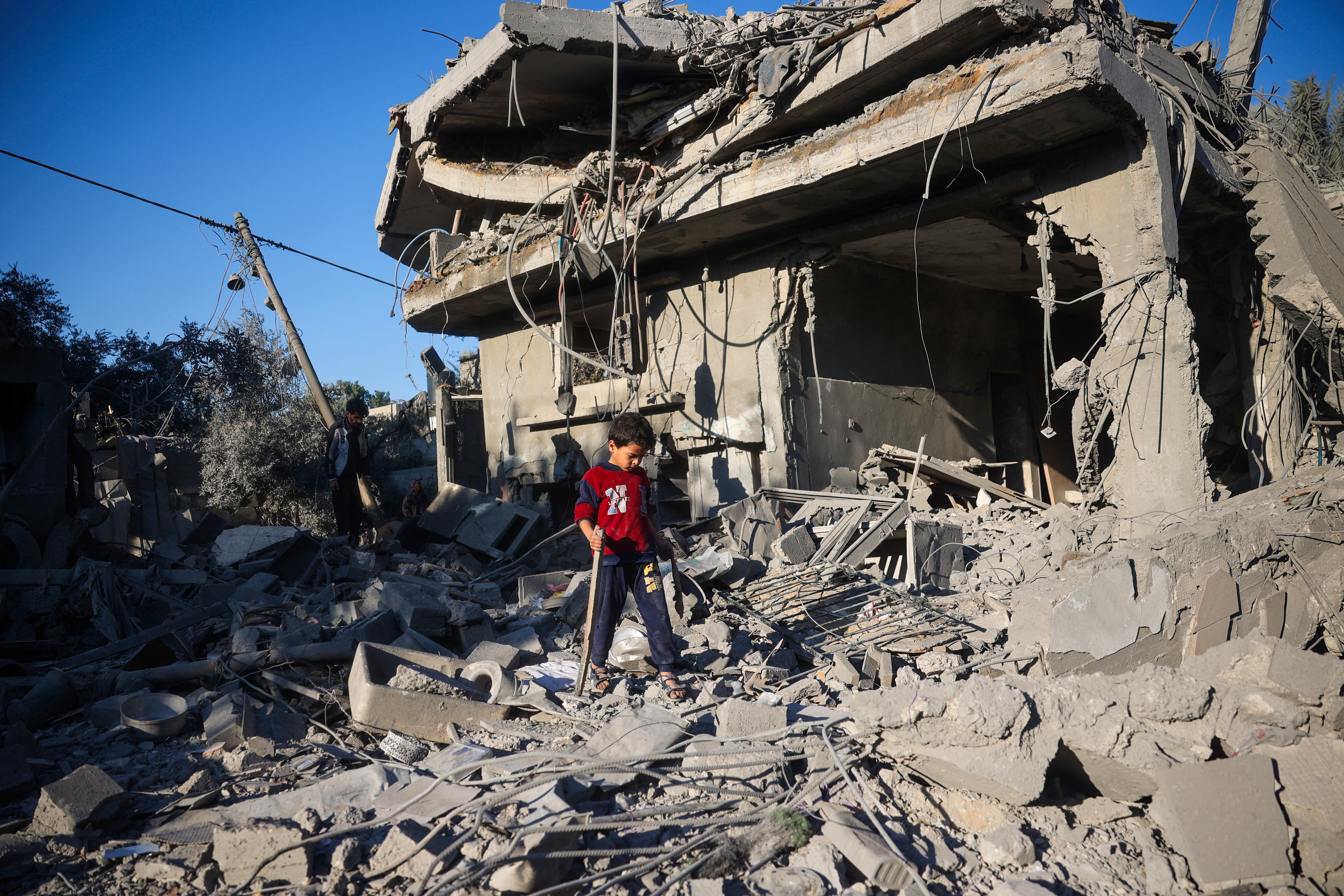 A boy walks on the rubble of a house destroyed in an Israeli strike at the Nuseirat refugee camp, central Gaza Strip