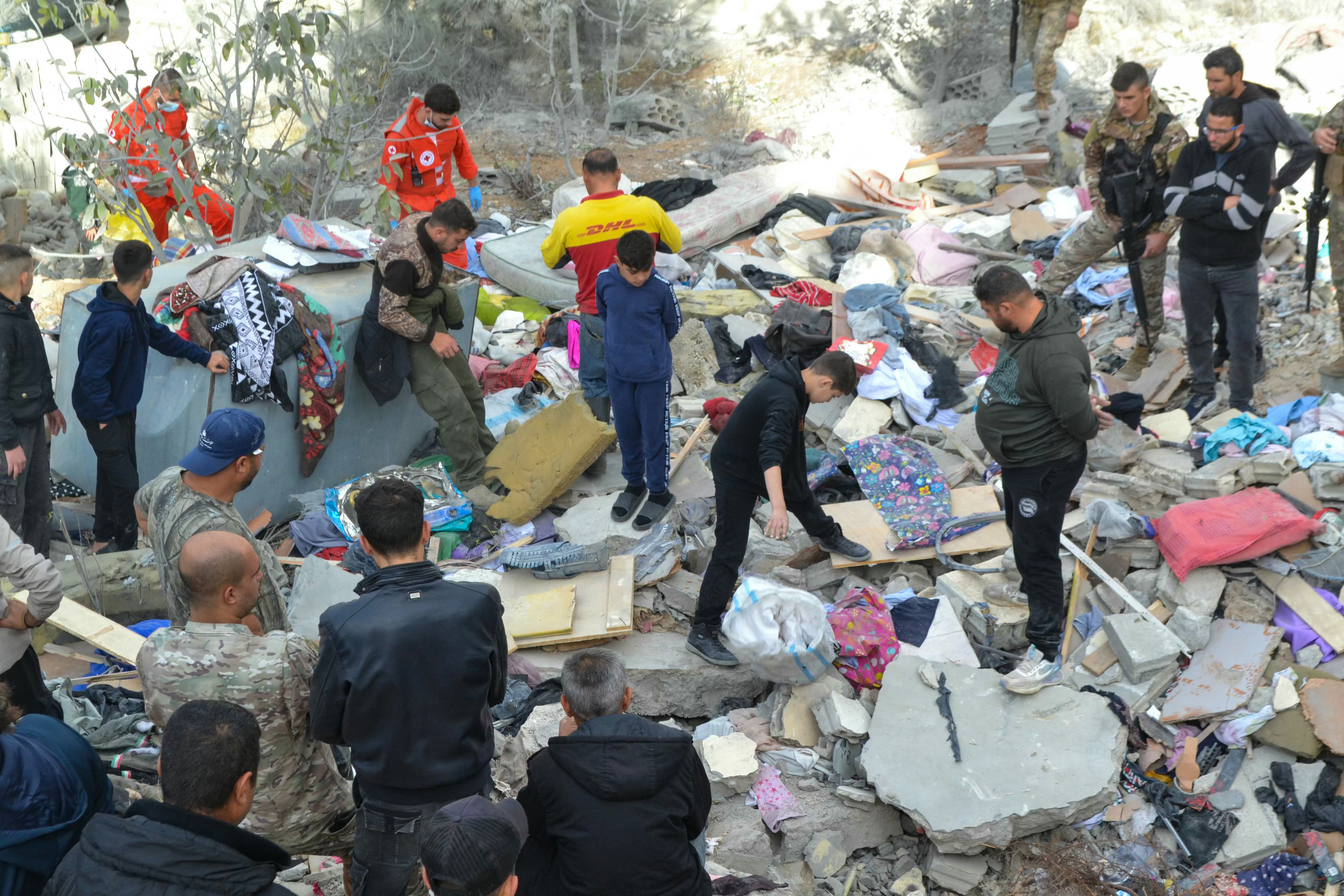 First responders and locals search the site of an overnight Israeli strike in Ain Yaacoub