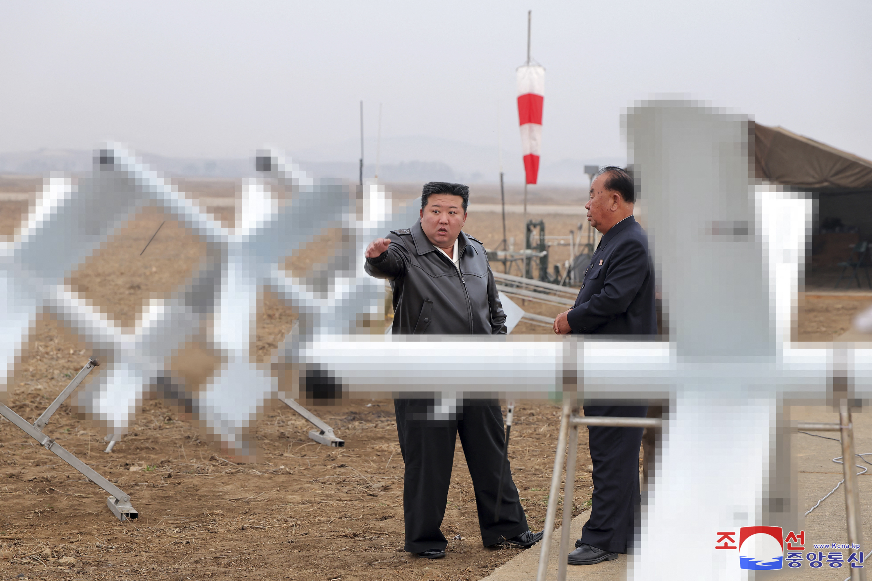 This picture taken on November 14, 2024 and released from North Korea's official Korean Central News Agency (KCNA) via KNS on November 15, 2024 shows North Korean leader Kim Jong Un (L) inspecting the performance test of suicide attack drones at an undisclosed location in North Korea. North Korean leader Kim Jong Un has ordered the "mass production" of suicide attack drones, state media reported on November 15, after he witnessed a test of the weapons system a day earlier. (Photo by KCNA VIA KNS / AFP) / SOUTH KOREA OUT / ---EDITORS NOTE--- RESTRICTED TO EDITORIAL USE - MANDATORY CREDIT "AFP PHOTO/KCNA VIA KNS" - NO MARKETING NO ADVERTISING CAMPAIGNS - DISTRIBUTED AS A SERVICE TO CLIENTS / THIS PICTURE WAS MADE AVAILABLE BY A THIRD PARTY. AFP CAN NOT INDEPENDENTLY VERIFY THE AUTHENTICITY, LOCATION, DATE AND CONTENT OF THIS IMAGE ---- IMAGE PIXELATED AT SOURCE