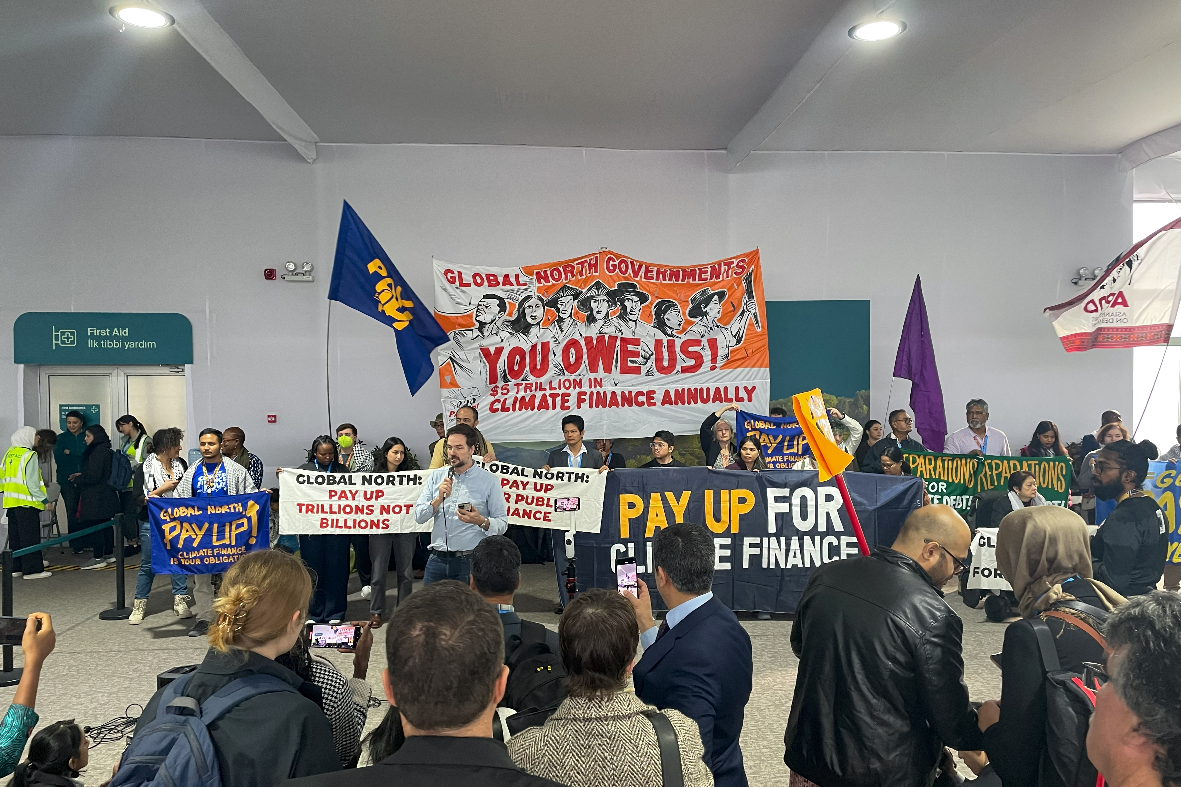 Activists with banners and flags hold a gathering to demand that rich countries help developing nations tackle global warming