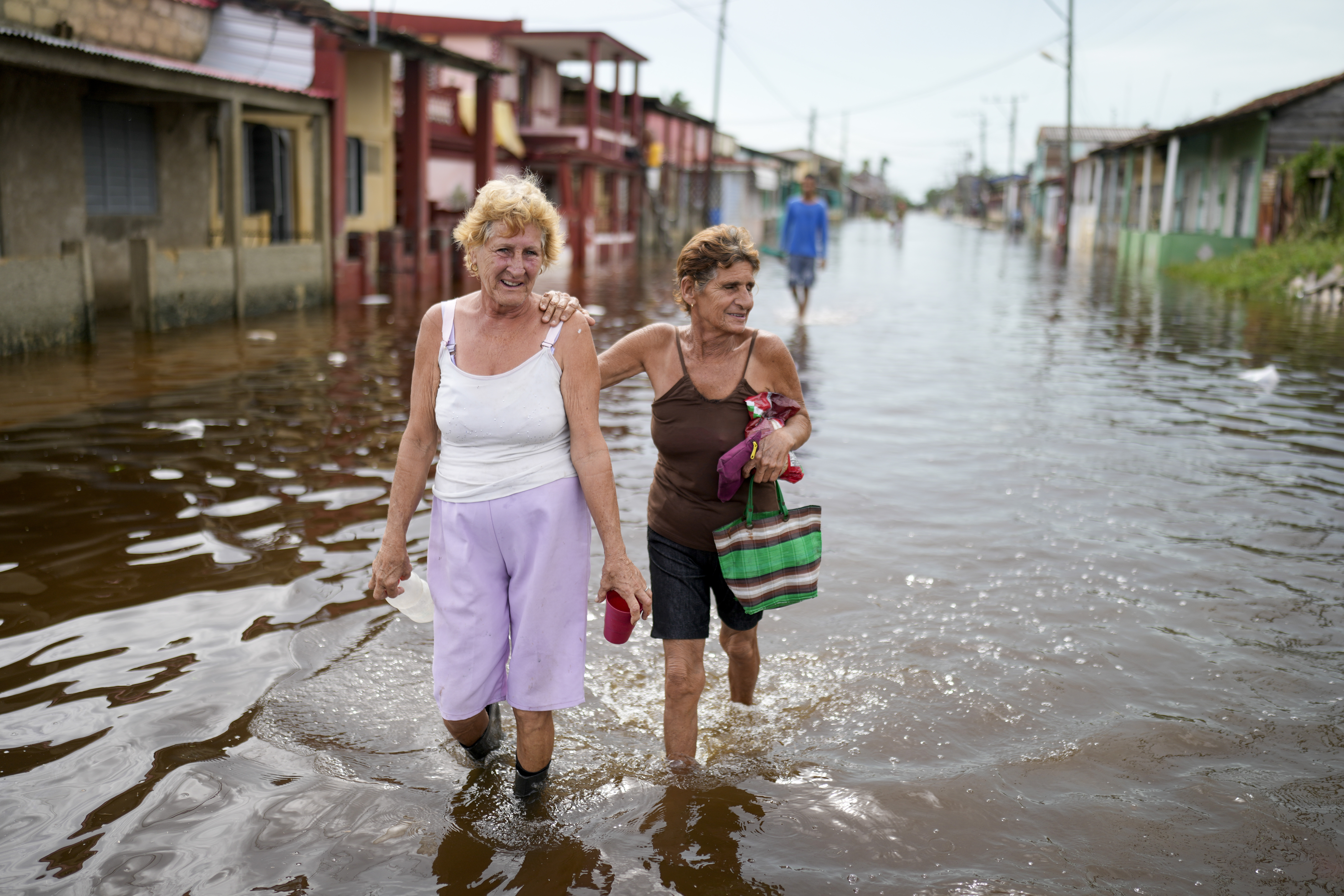 Women walking in flooded street in Cuba after Hurricane Rafael