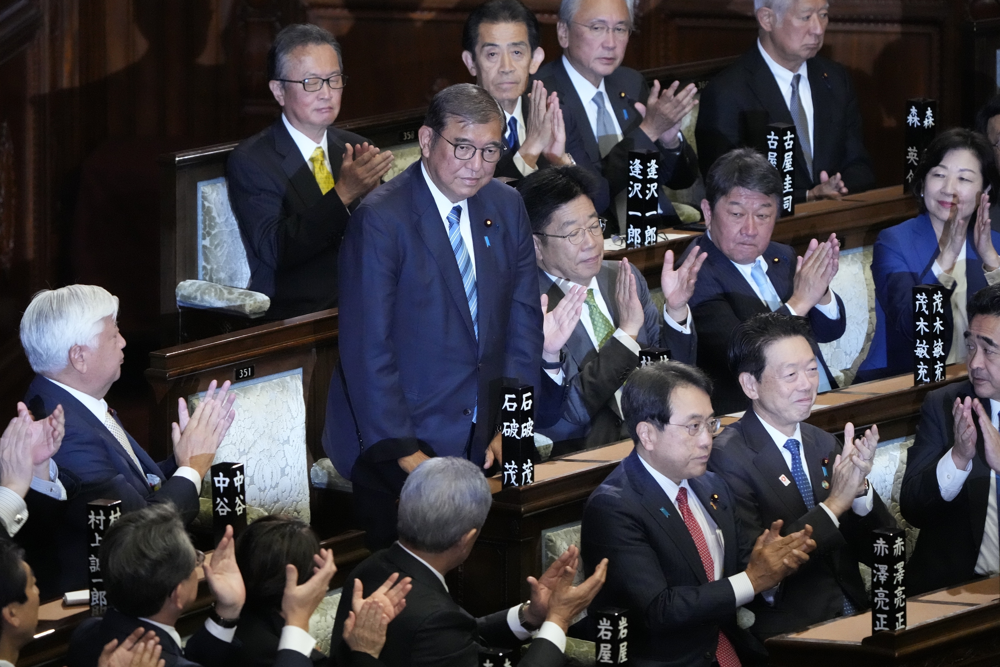 Lawmakers applaud as Japanese Prime Minister Shigeru Ishiba, standing, was elected for a new prime minister at a special parliamentary session of the lower house Monday, Nov. 11, 2024, in Tokyo. (AP Photo/Eugene Hoshiko)