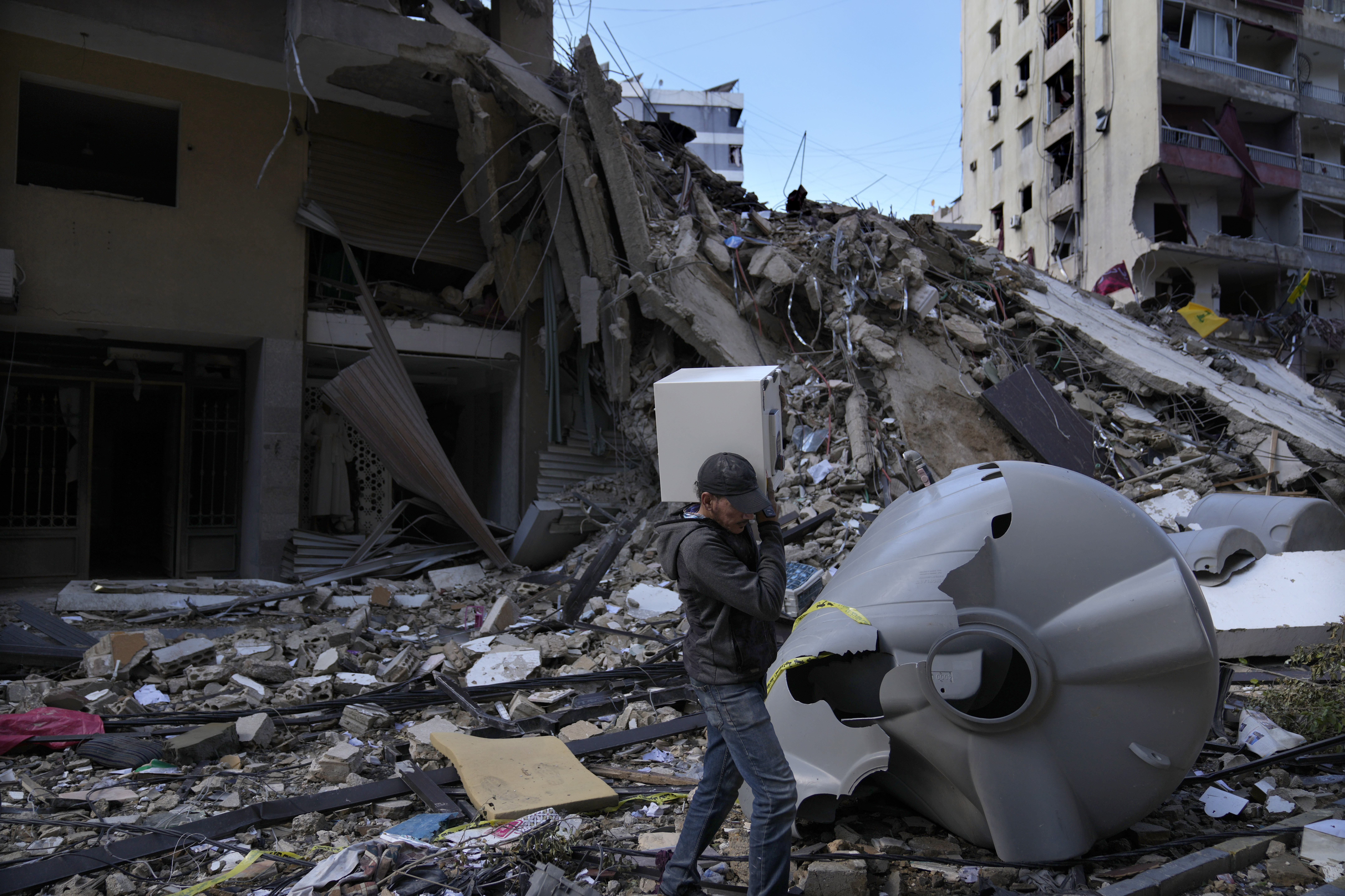 A man carries a safe box after he pulls it out of a destroyed building that was hit by an Israeli airstrike in Dahiyeh, in the southern suburb of Beirut