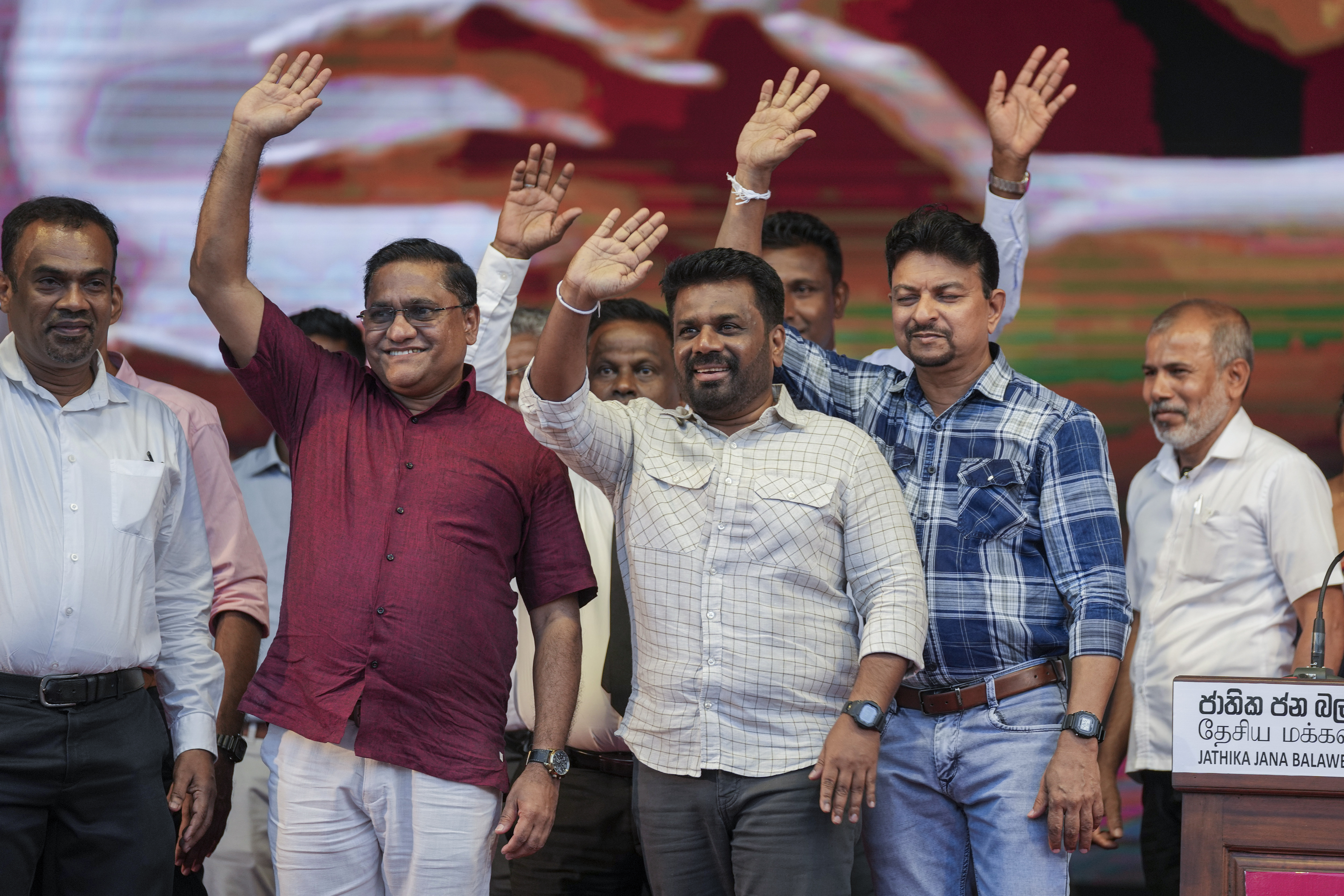 Sri Lankan President Anura Kumara waves with other candidates during a rally