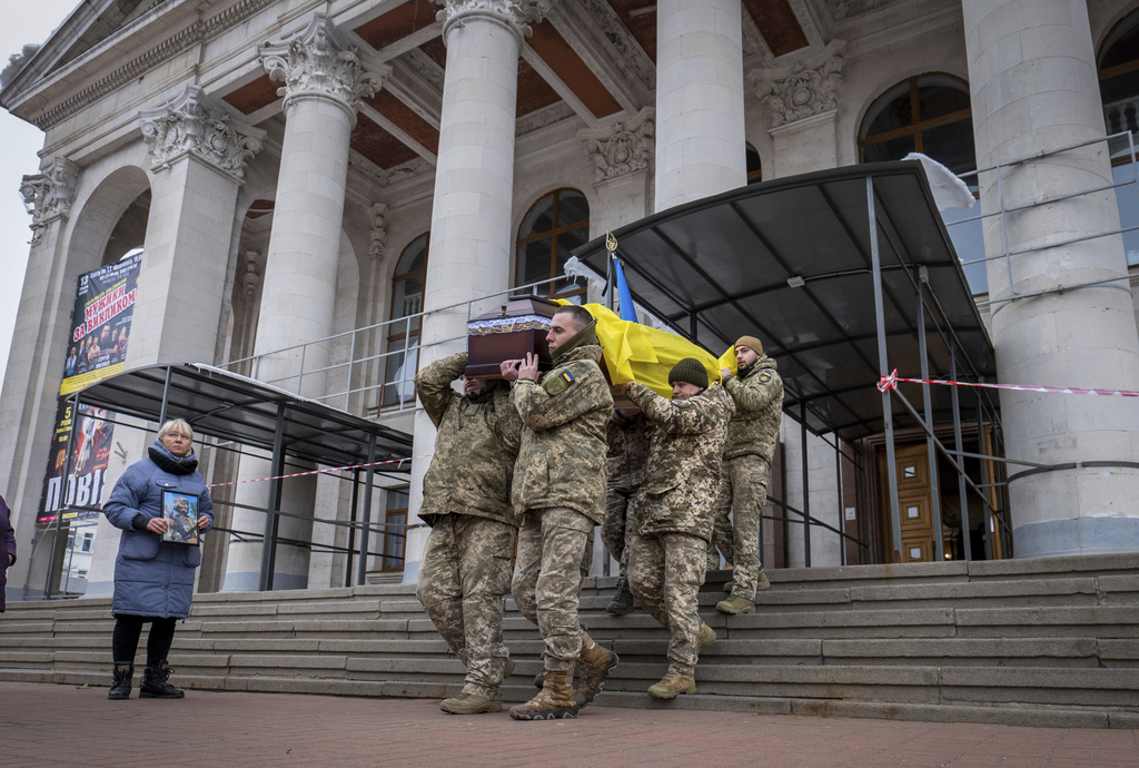 Fellow soldiers carry a coffin of leading actor Petro Velykiy, 48, who was killed in a battle with the Russian troops in Russia's Kursk region, during farewell ceremony in the music and drama theatre in Chernyhiv, Ukraine, Wednesday, Nov. 27, 2024.(AP Photo/Dan Bashakov)