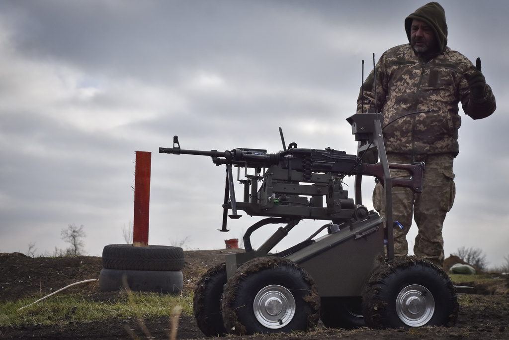 In this photo provided by Ukraine's 65th Mechanised Brigade press service, a serviceman explains how to operate a Gnom 2 ground drone in Zaporizhzhia region, Ukraine, Friday, Nov. 29, 2024. (Andriy Andriyenko/Ukraine's 65th Mechanised Brigade via AP)