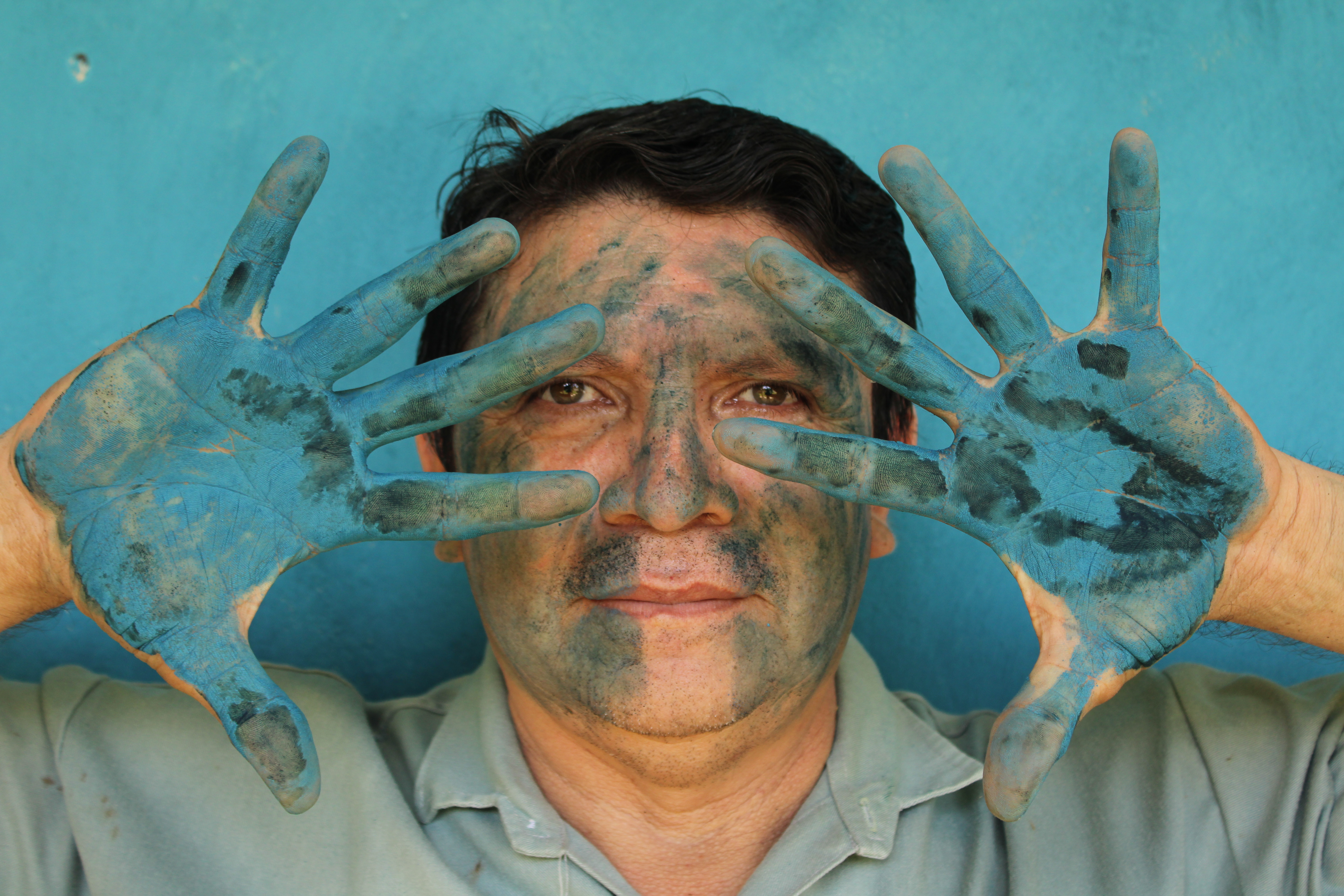 Luis May Ku, 49, poses with his hands painted in Maya Blue outside his home in Dzan, Yucatán, Mexico, on 9 September, 2024