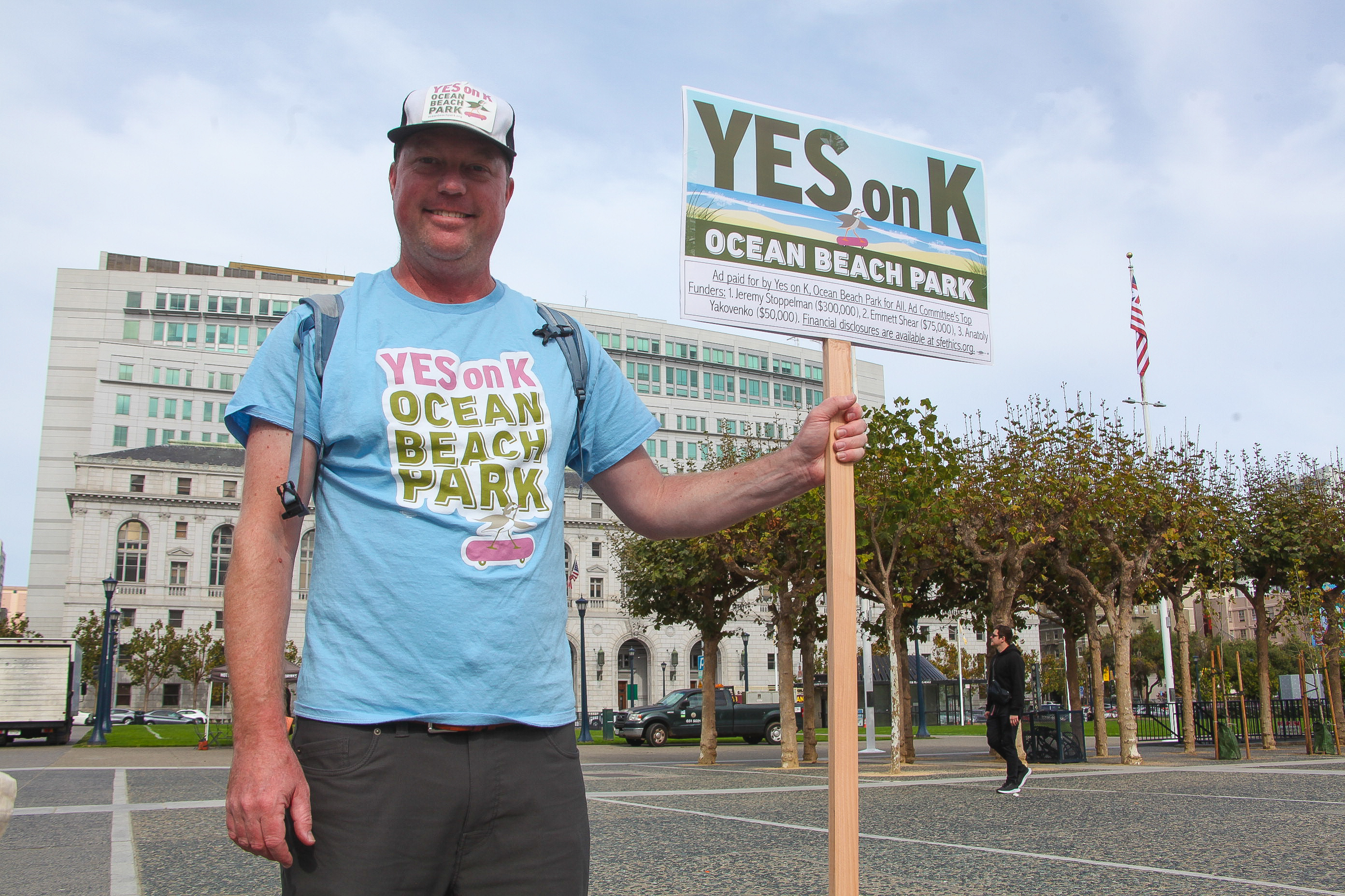 A voter holds up a sign in San Francisco that says, "Yes on K"