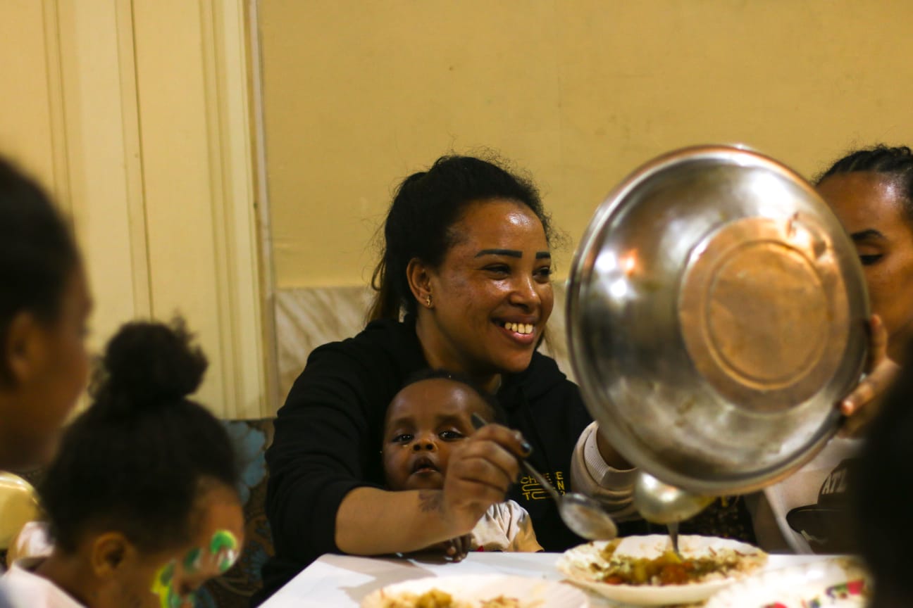 Sudanese-women-and-children-gather-to-eat-dinner-together-