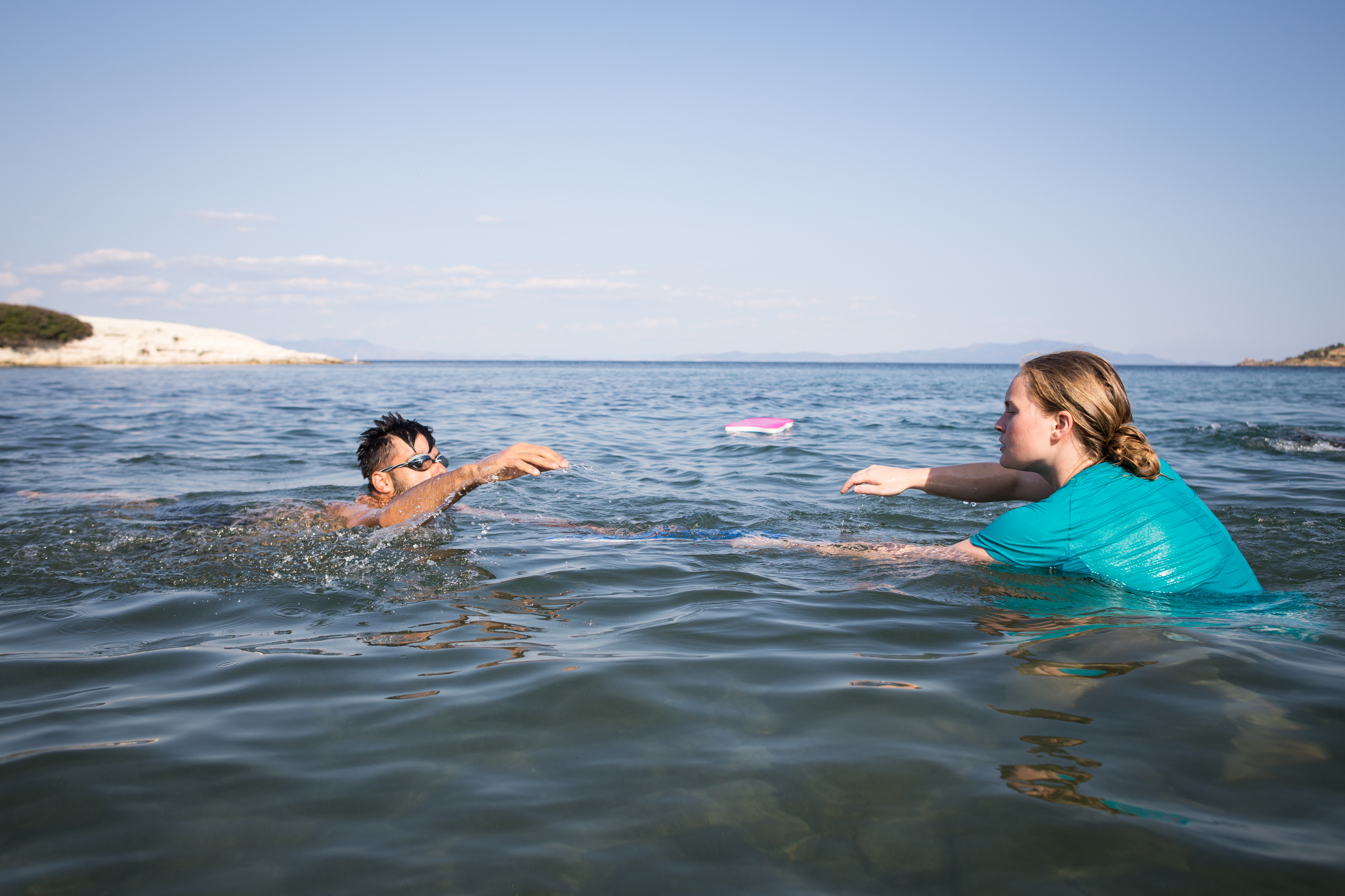 Zara Waddy, an instructor from the UK, helps one of the swimming students during a weekly session. [Giacomo Sini/Al Jazeera]
