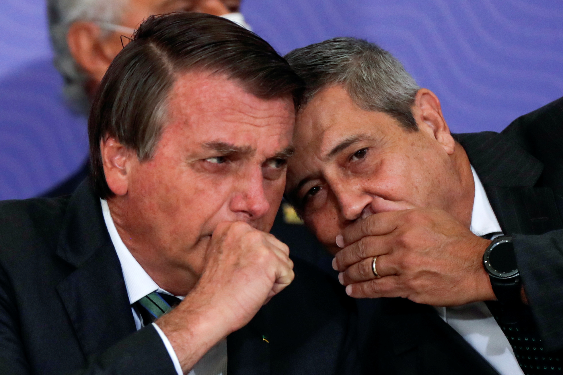 Bolsonaro and his former defence minister Walter Braga Netto whisper together during a meeting