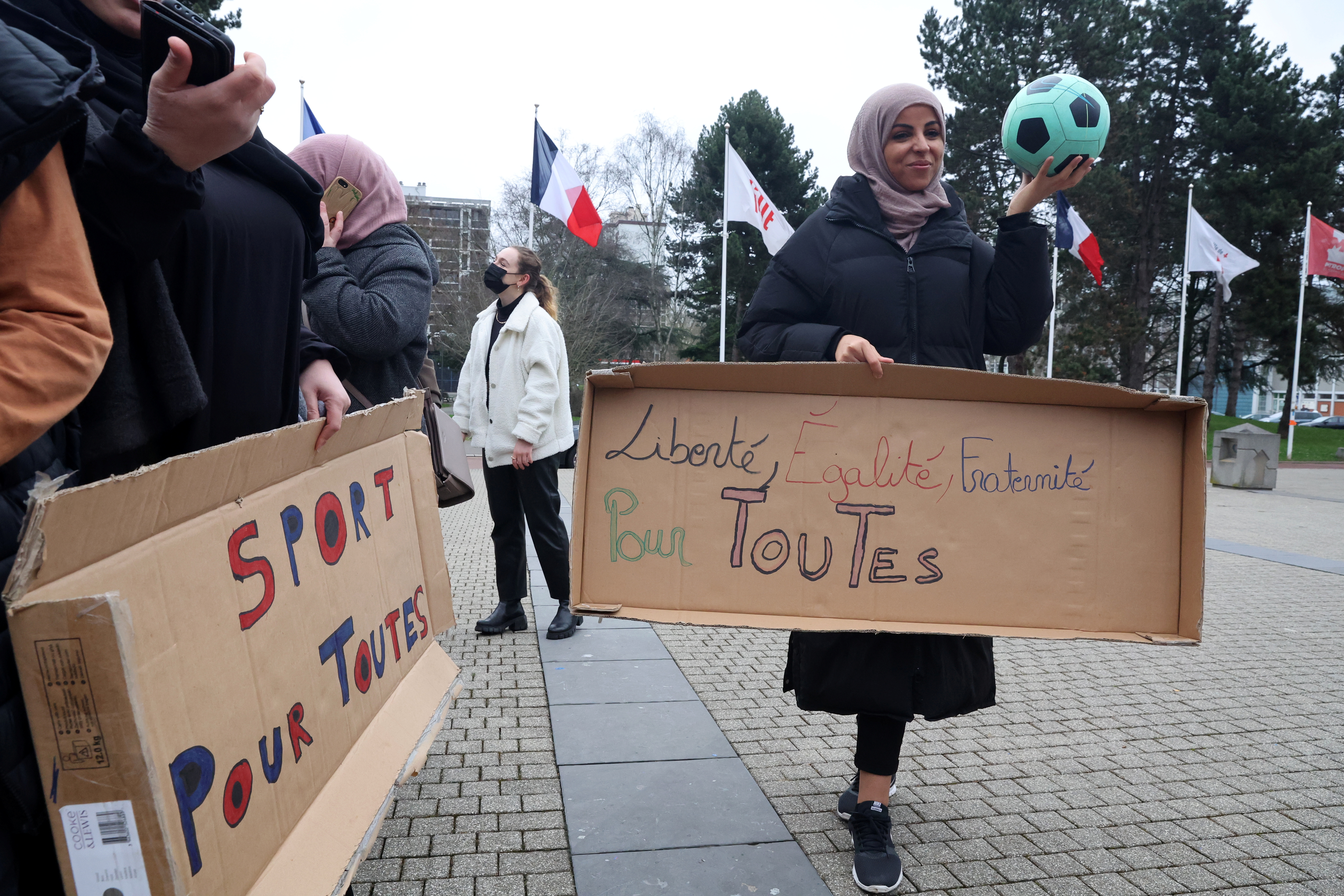 Supporters of the women soccer team "Les Hijabeuses" gather in front of the city hall in Lille as part of a protest as French Senate examines a bill featuring controversial hijab ban in competitive sports in France, February 16, 2022. The slogans read "Sport for all" and "Liberty, Egality, Fraternity for all". REUTERS/Pascal Rossignol