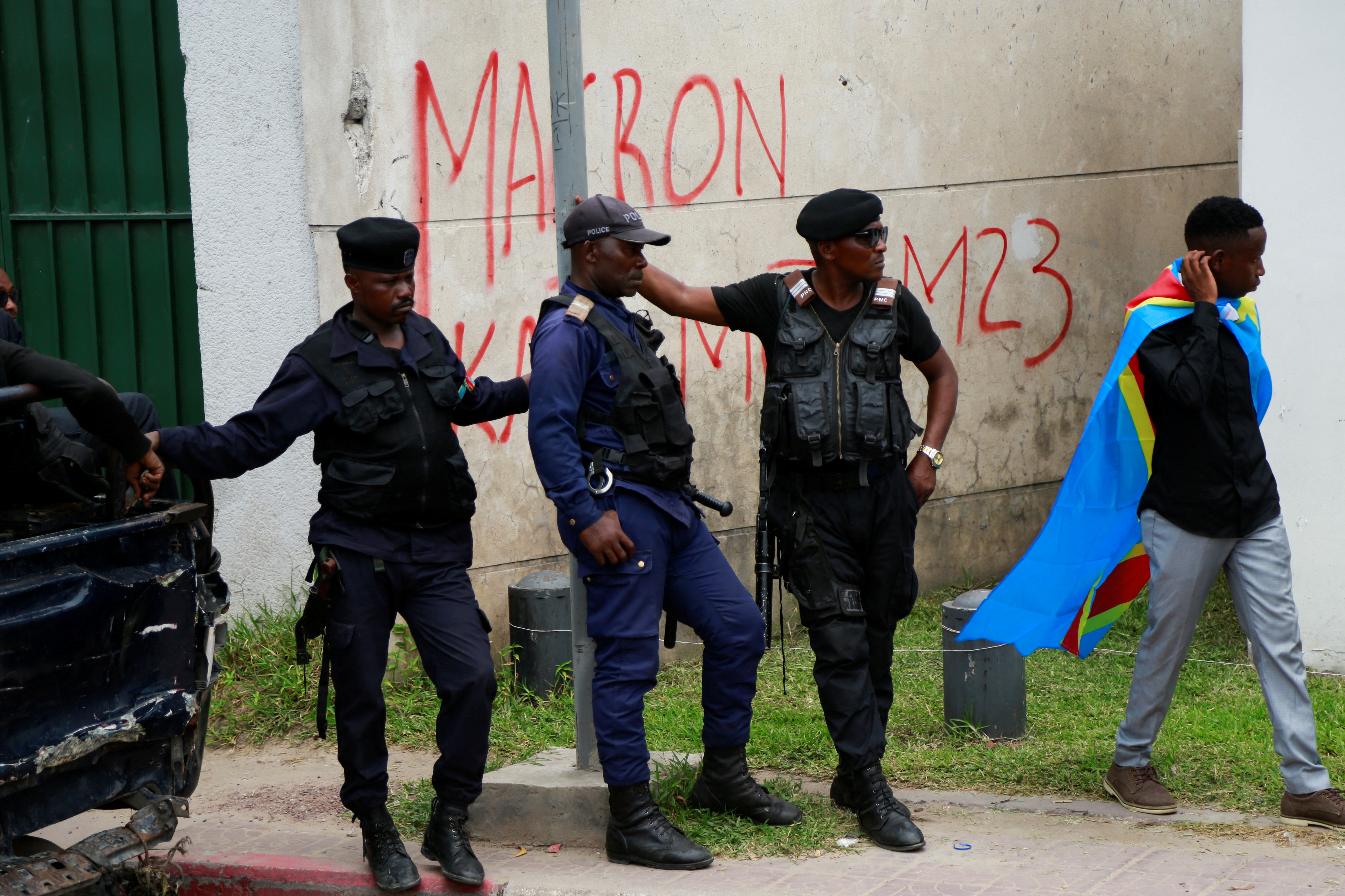 Police officers watch demonstrators as they hold a sit-in to protest against the visit of the French President Emmanuel Macron and France's perceived support for neighbouring Rwanda, which Congo accuses of supporting M23 rebels in the east, in front of the French embassy in Kinshasa, Democratic Republic of Congo March 1, 2023. REUTERS/Justin Makangara