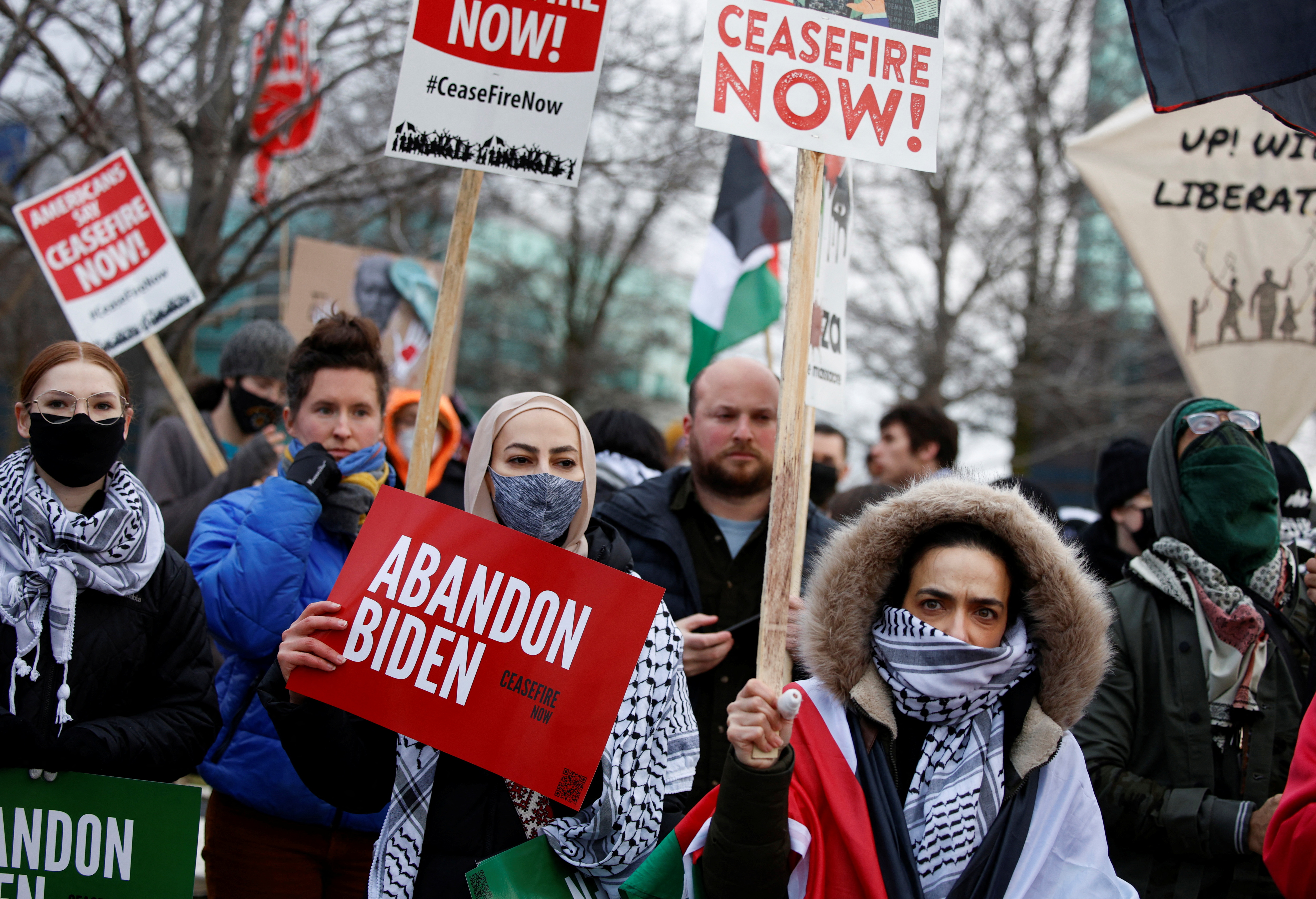 Protesters at a rally in Michigan hold up signs that read "Ceasefire now" and "Abandon Biden"