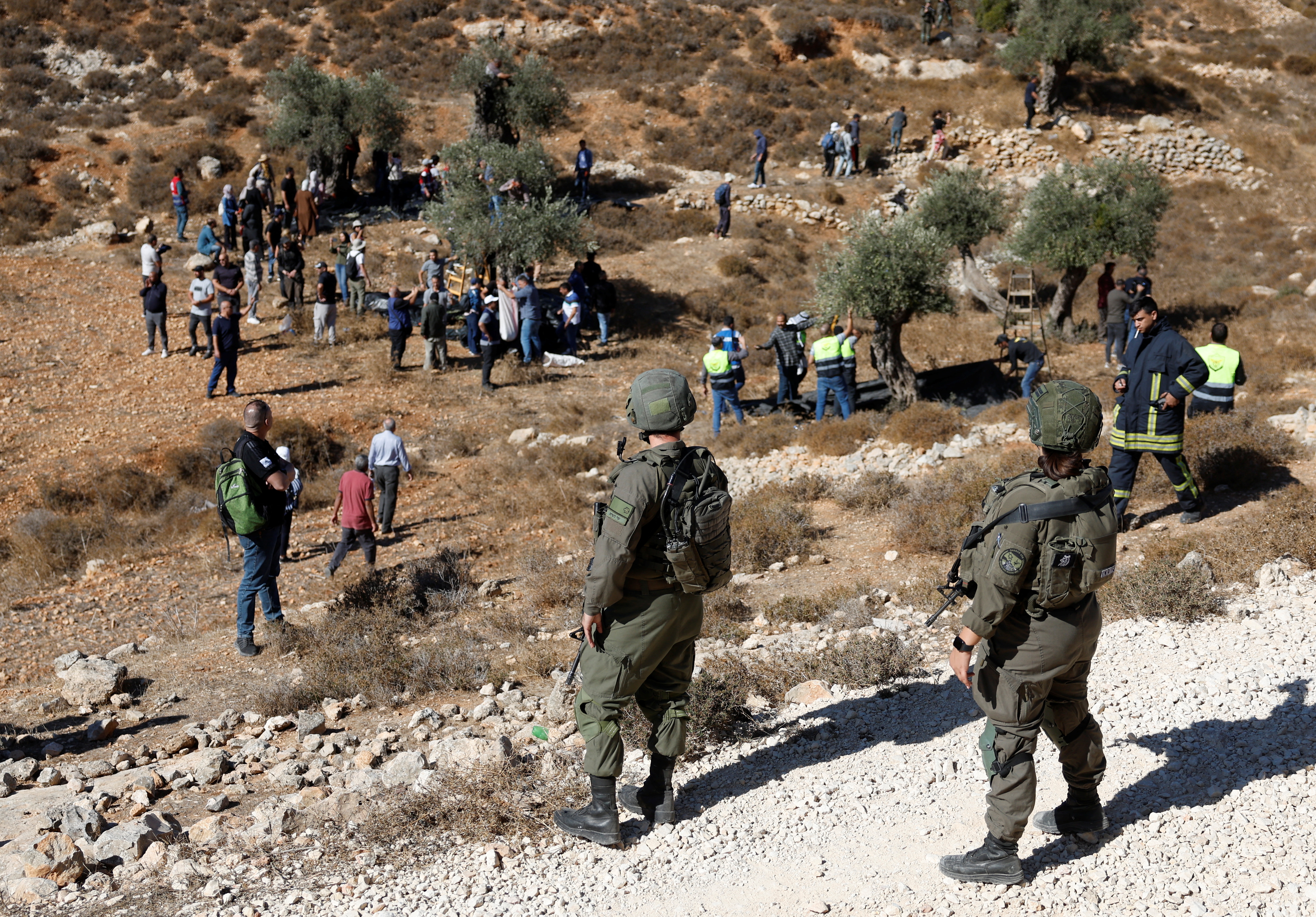 Israeli soldiers stand guard as Israeli troops deny access to Palestinian farmers to harvest olives, in Burqa near Ramallah in the Israeli-occupied West Bank October 20, 2024. REUTERS/Mohammed Torokman