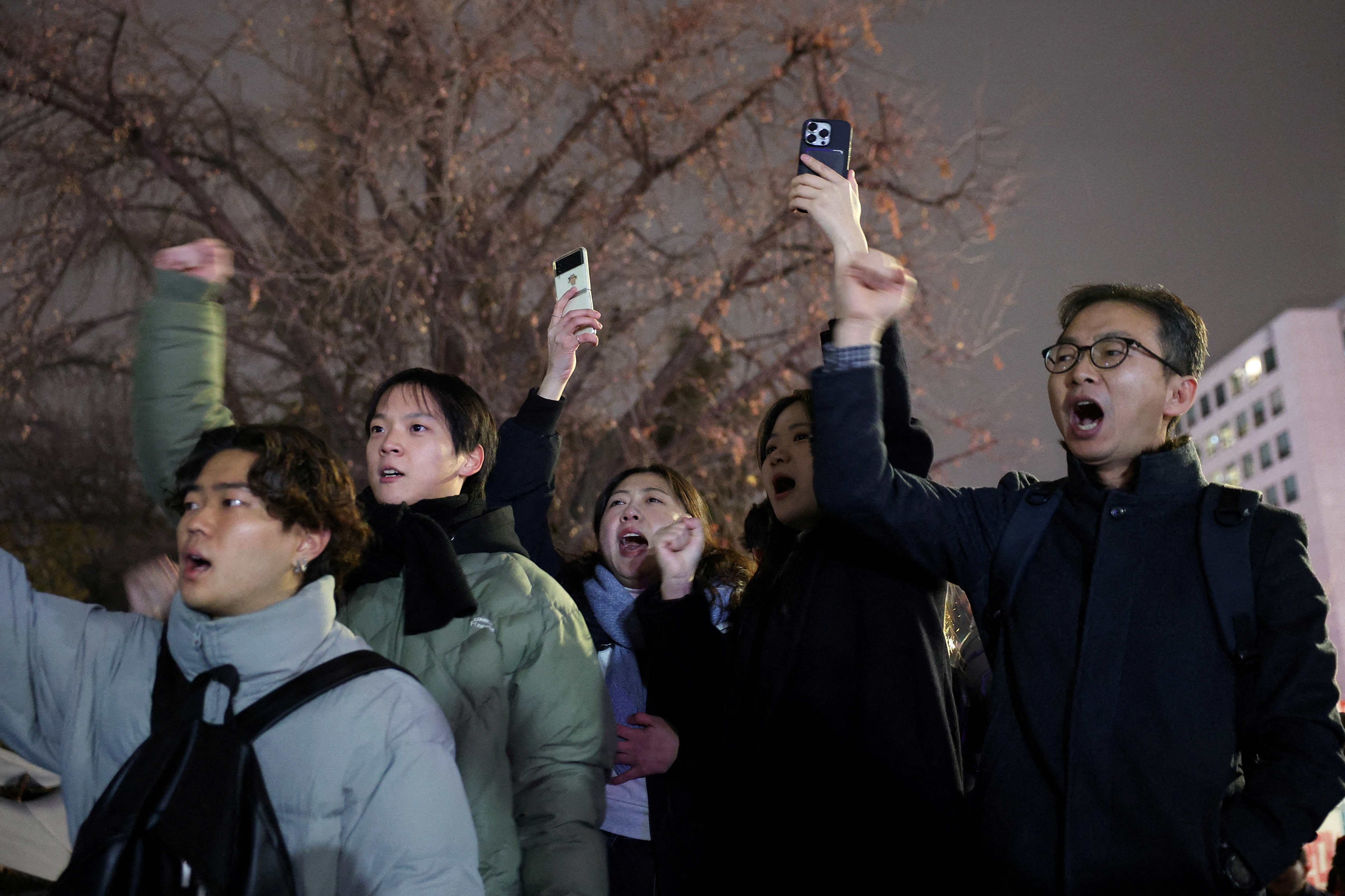 People shout slogans in front of the gate of the National Assembly