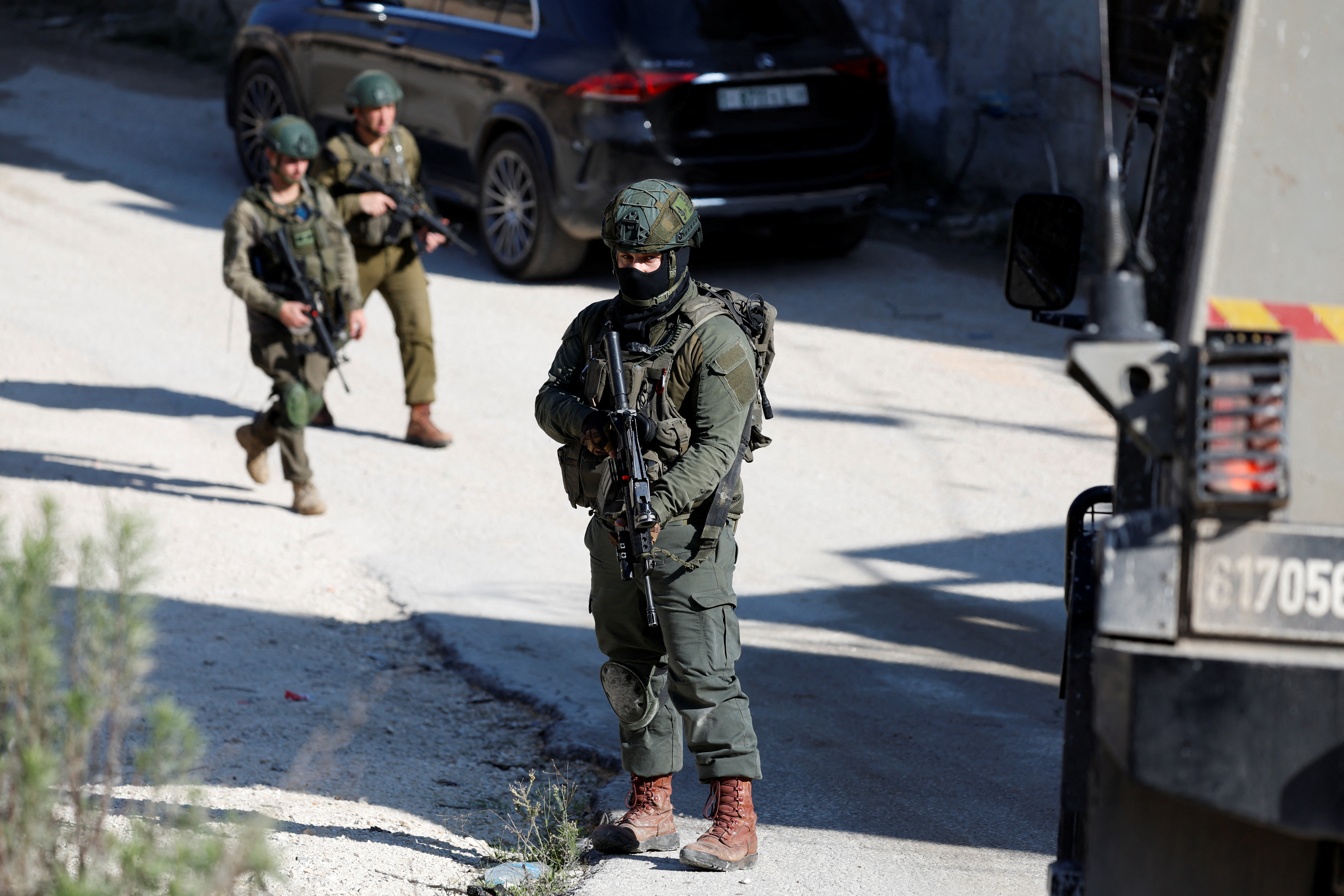 An Israeli soldier stands guard, after an Israeli settlers attack in Hawara near Nablus