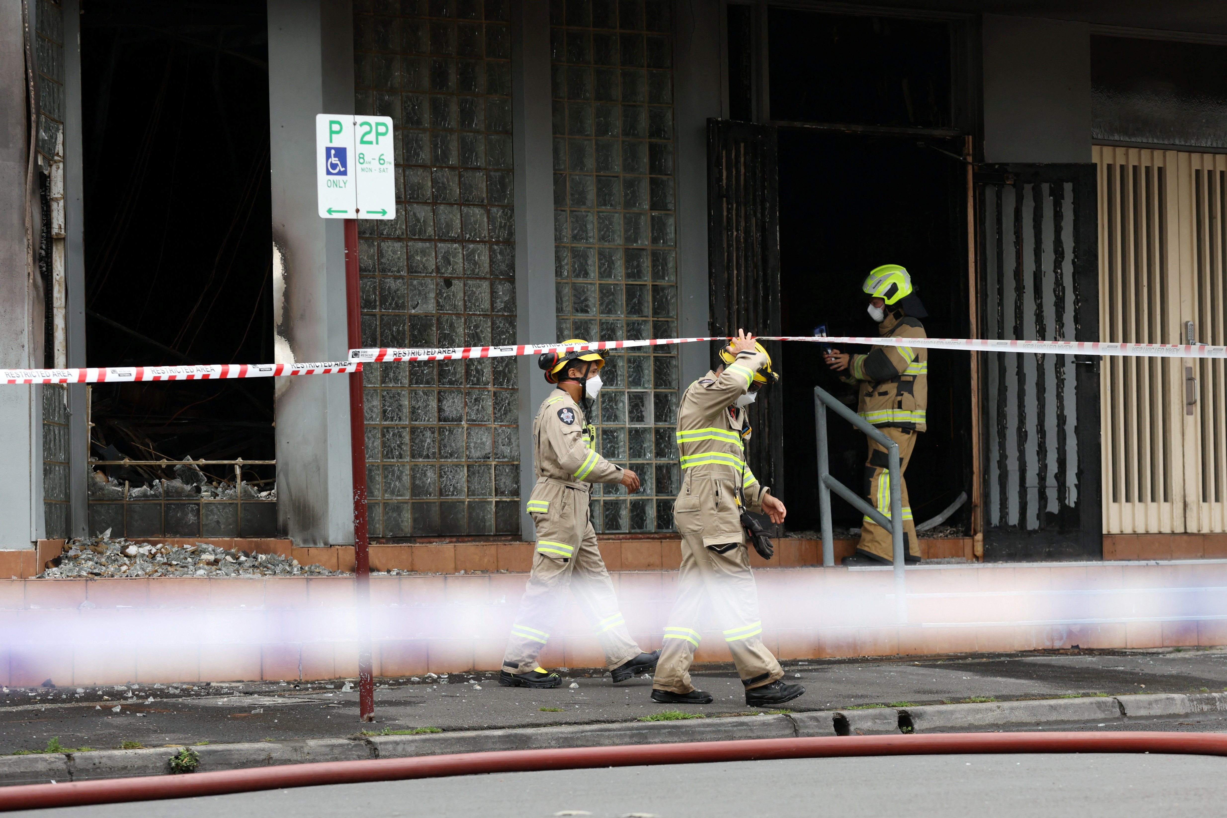 Firefighters work at the scene of a fire at the Adass Israel Synagogue