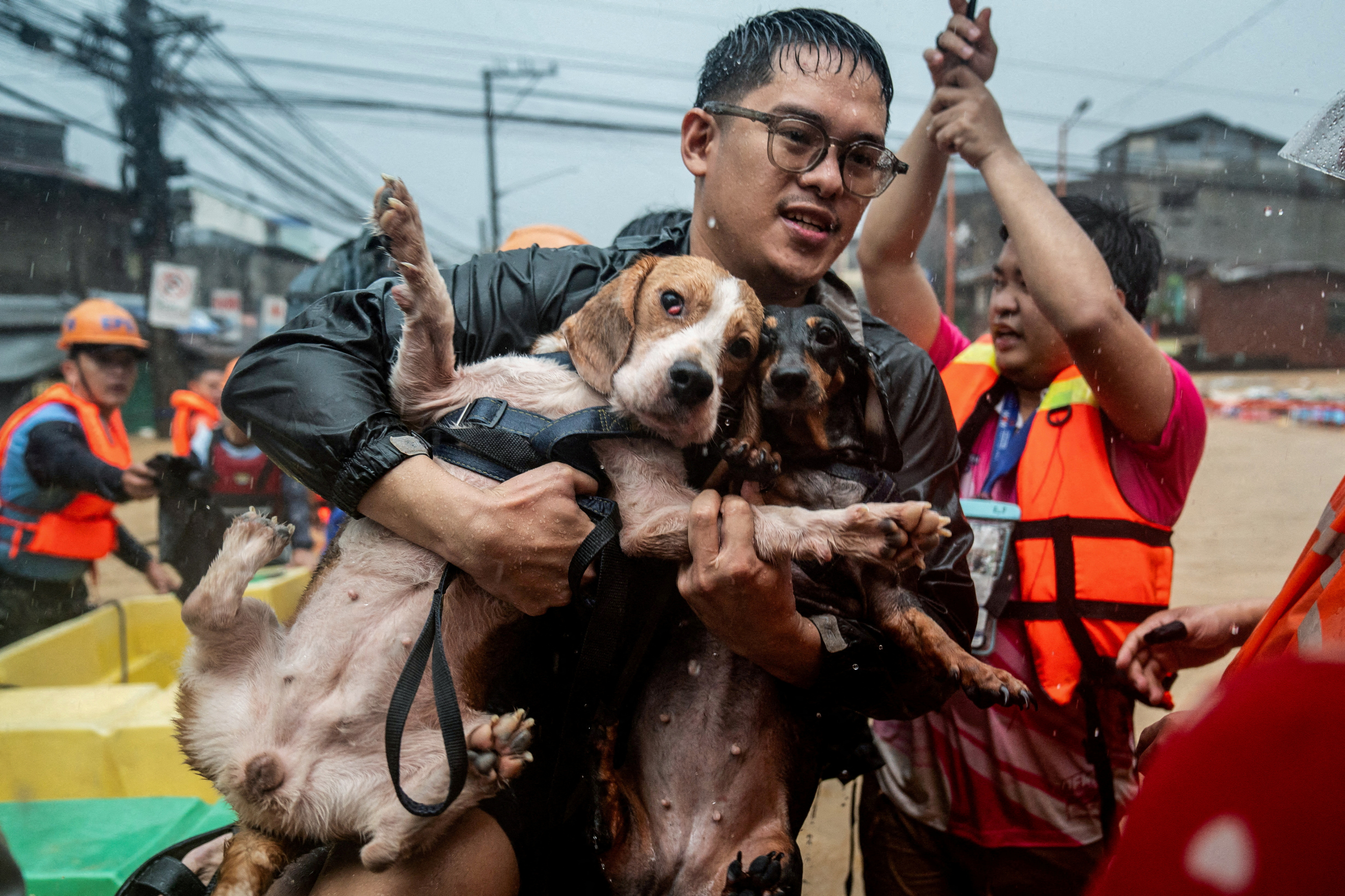 A man carrying his dogs gets off a boat along a flooded road following heavy rains brought by Typhoon Gaemi, in Marikina City, Metro Manila, Philippines, July 2