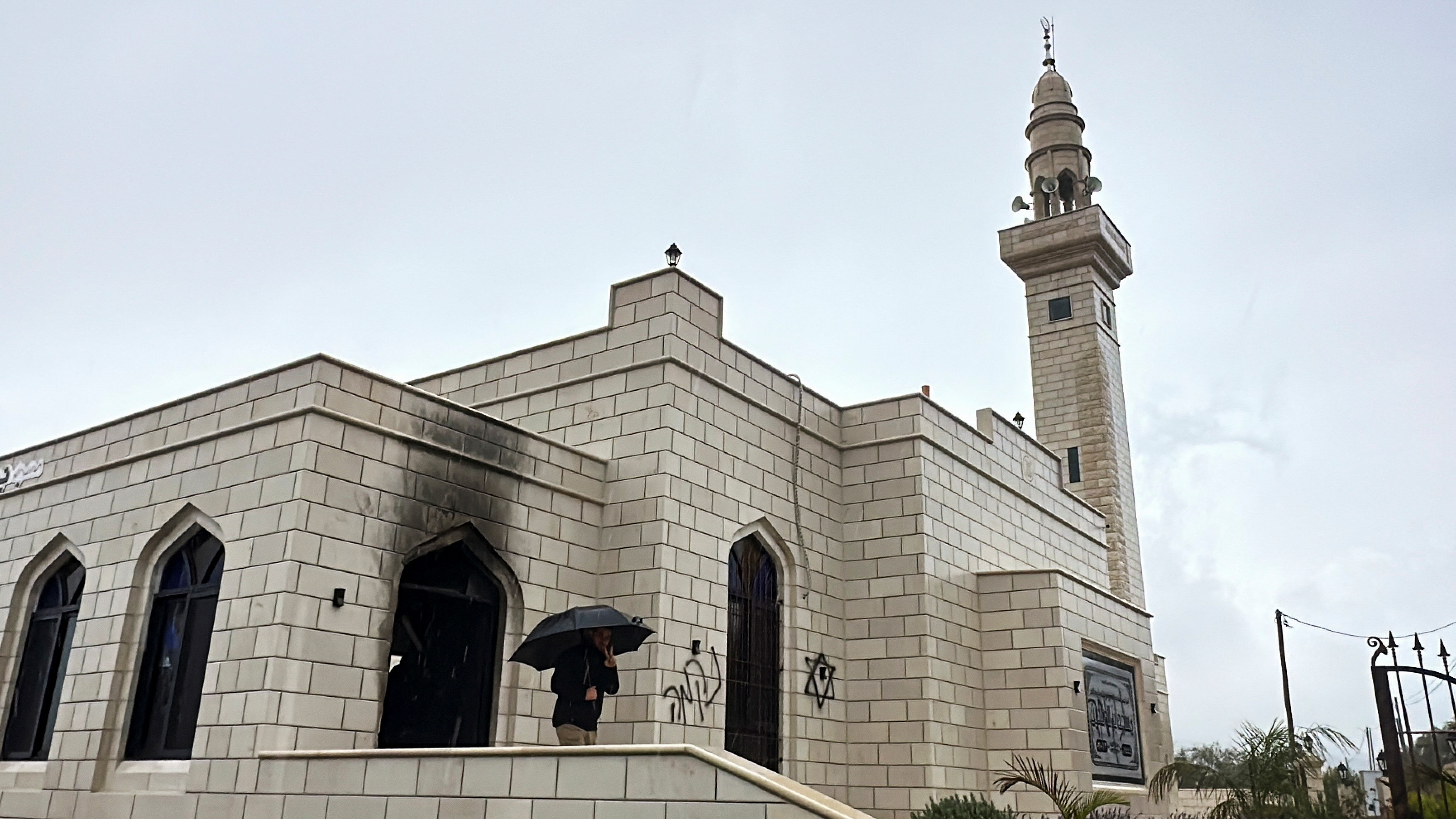 A person stands at a damaged mosque, which according to Palestinians was burned by Israeli settlers, near Salfit in the Israeli-occupied West Bank December 20, 2024. RETUERS/Stringer