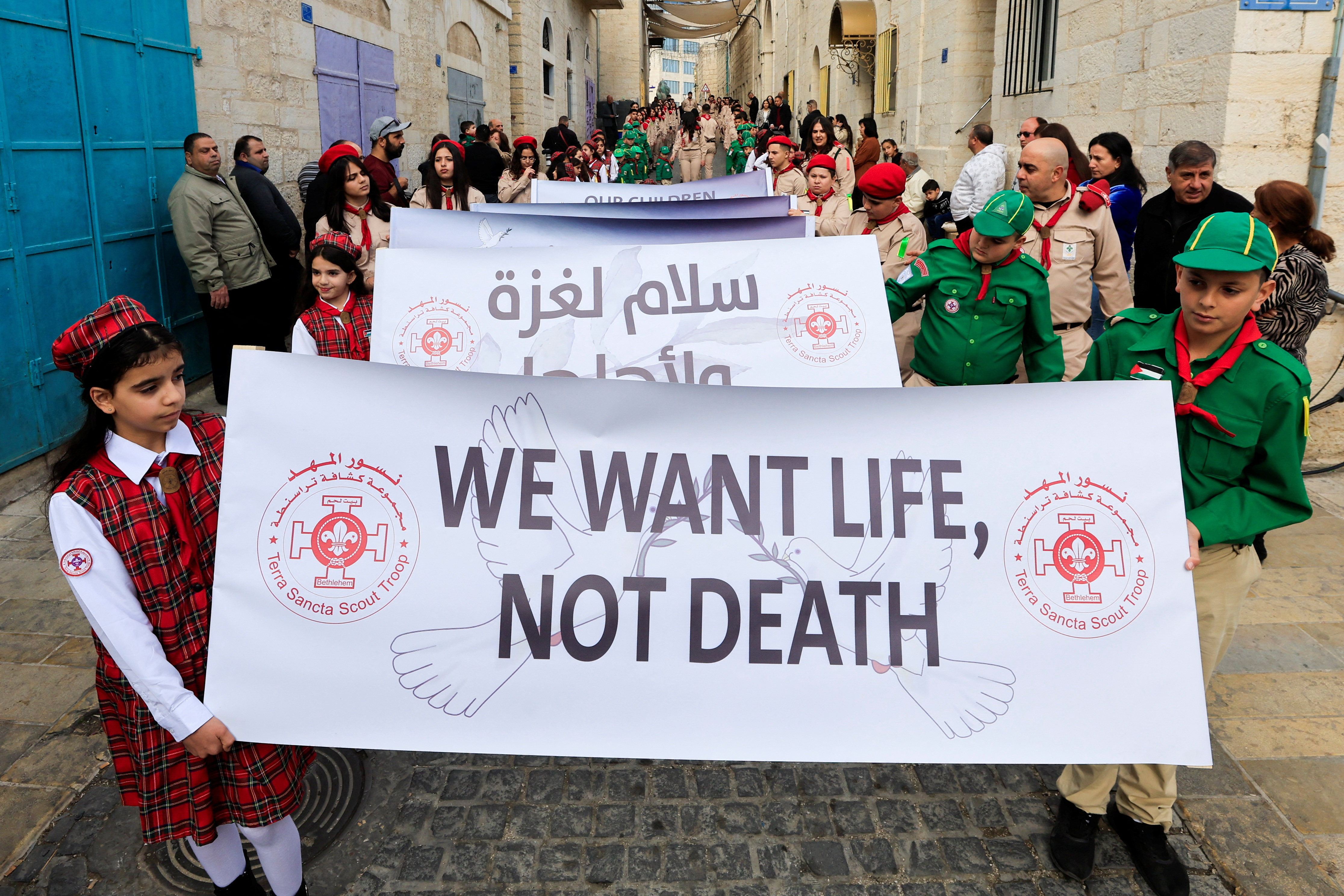 Scouts hold placards ahead of the arrival of Latin Patriarch of Jerusalem, Pierbattista Pizzaballa to attend Christmas events