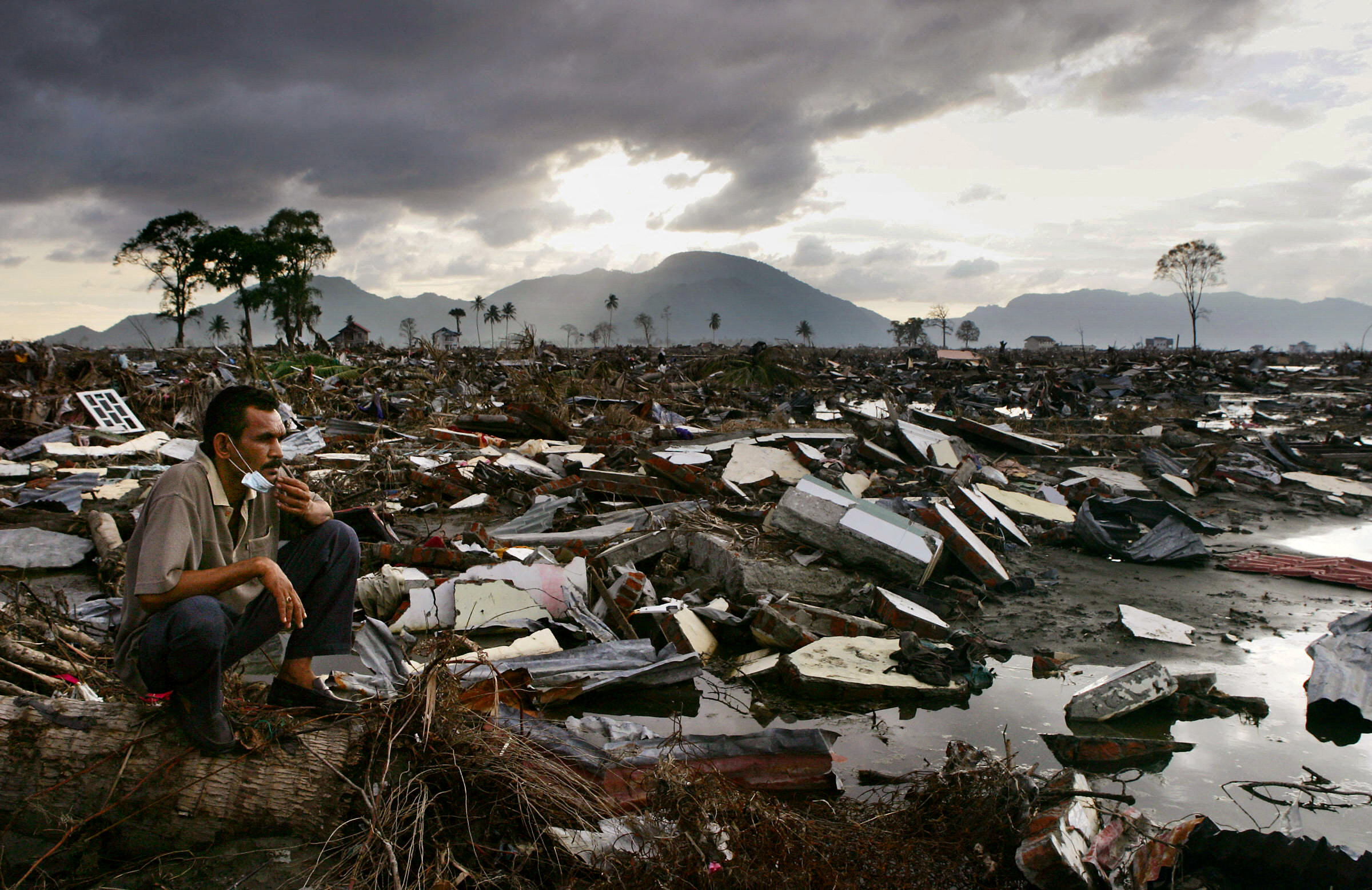 An Acehnese man lingers at the ruins in Banda Aceh, 13 January 2005. An estimated 400,000 people in the country worst-hit by the December 26 disaster lost not only their family and homes but also their jobs, many escaping with nothing more than the clothes they were wearing. AFP PHOTO/Kazuhiro NOGI (Photo by Kazuhiro NOGI / AFP)