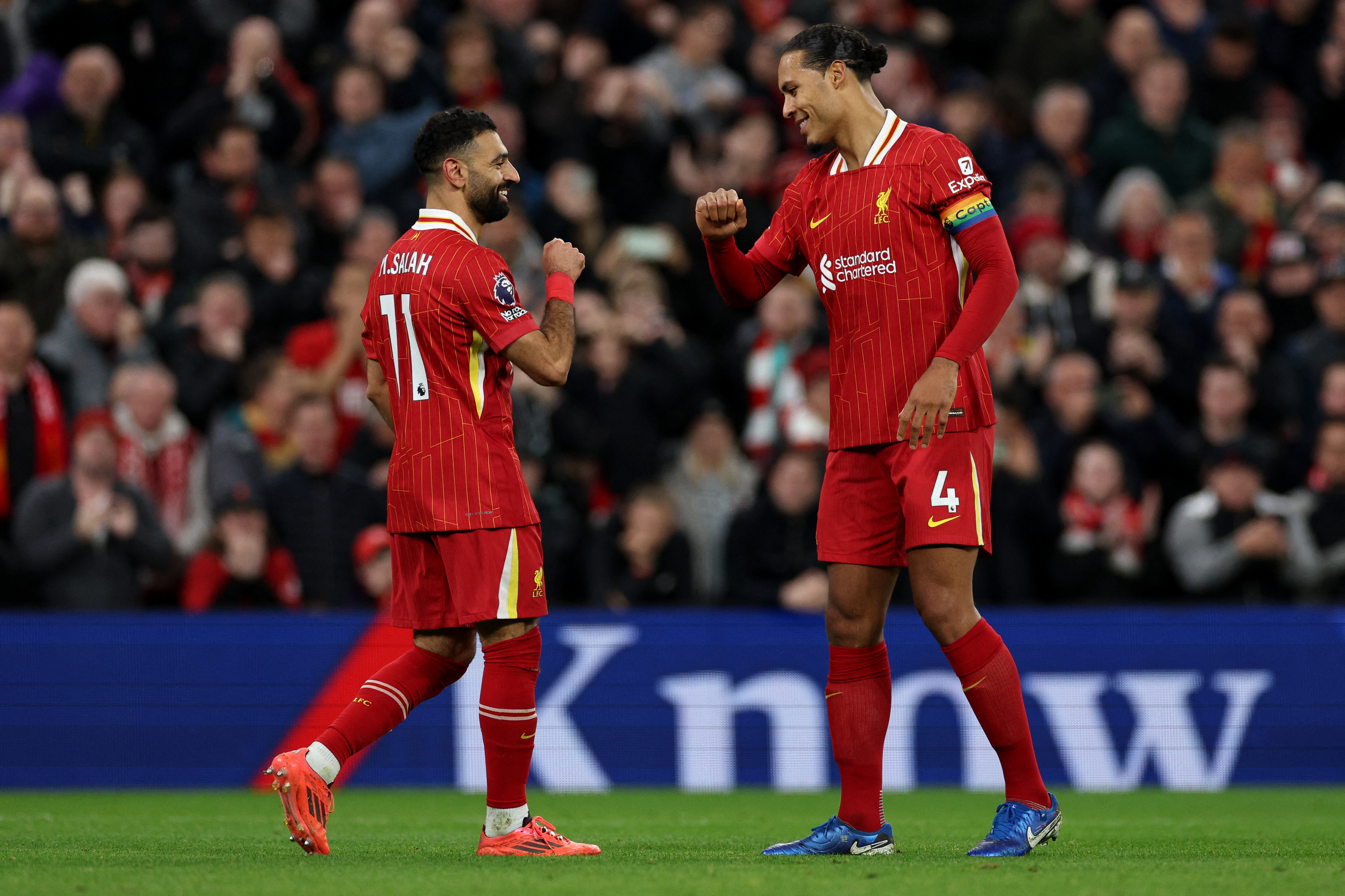 Liverpool's Egyptian striker #11 Mohamed Salah (L) celebrates with Liverpool's Dutch defender #04 Virgil van Dijk after scoring the team's second goal during the English Premier League football match between Liverpool and Manchester City at Anfield in Liverpool, north west England on December 1, 2024. (Photo by Adrian Dennis / AFP) / RESTRICTED TO EDITORIAL USE. NO USE WITH UNAUTHORIZED AUDIO, VIDEO, DATA, FIXTURE LISTS, CLUB/LEAGUE LOGOS OR 'LIVE' SERVICES. ONLINE IN-MATCH USE LIMITED TO 120 IMAGES. AN ADDITIONAL 40 IMAGES MAY BE USED IN EXTRA TIME. NO VIDEO EMULATION. SOCIAL MEDIA IN-MATCH USE LIMITED TO 120 IMAGES. AN ADDITIONAL 40 IMAGES MAY BE USED IN EXTRA TIME. NO USE IN BETTING PUBLICATIONS, GAMES OR SINGLE CLUB/LEAGUE/PLAYER PUBLICATIONS. /