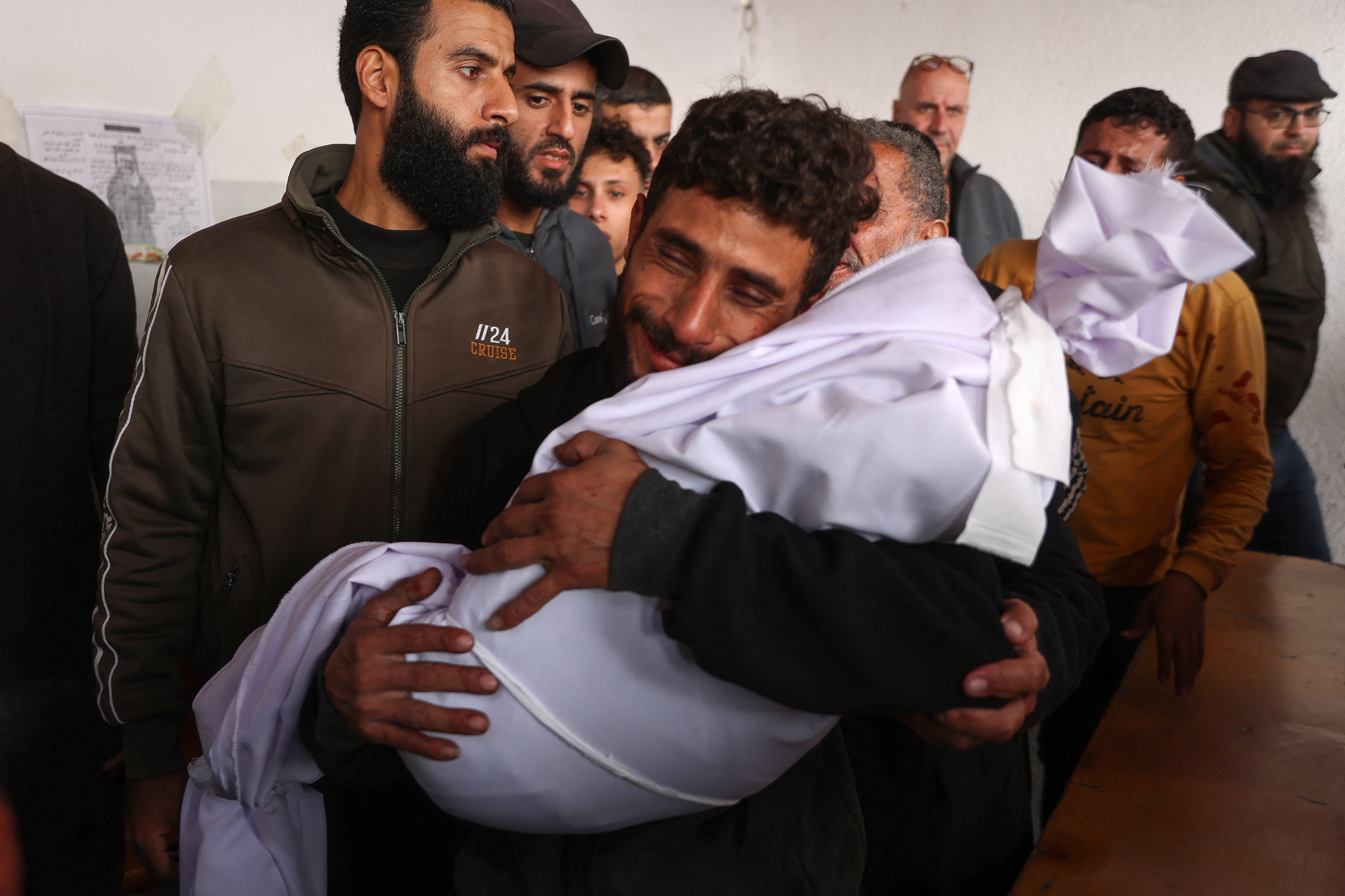 A man cries as he holds the body of a two-year-old child who was killed from shrapnel following an Israeli strike in Gaza City, at Al-Ahli Arab hospital, also known as the Baptist hospital on December 5, 2024, as the war between Israel and Hamas militants continues. (Photo by Omar AL-QATTAA / AFP)