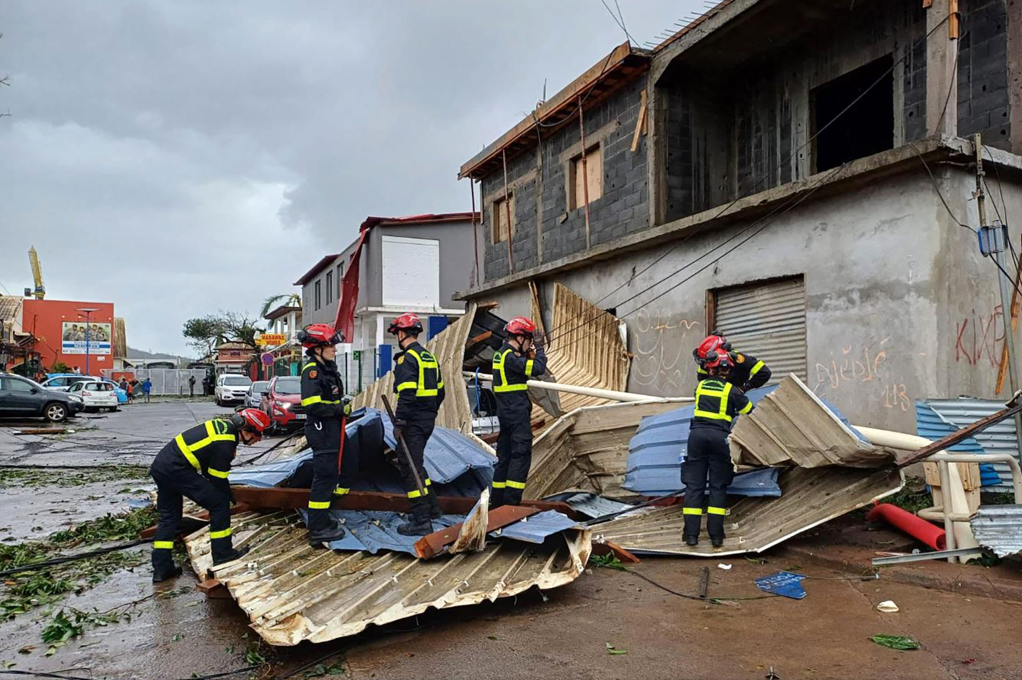 This handout photograph released by the Securite Civile on December 15, 2024 and taken at an undisclosed location on the French Indian Ocean territory of Mayotte shows members of the French Civil Security cleaning debris after the cyclone Chido hit the archipelago.