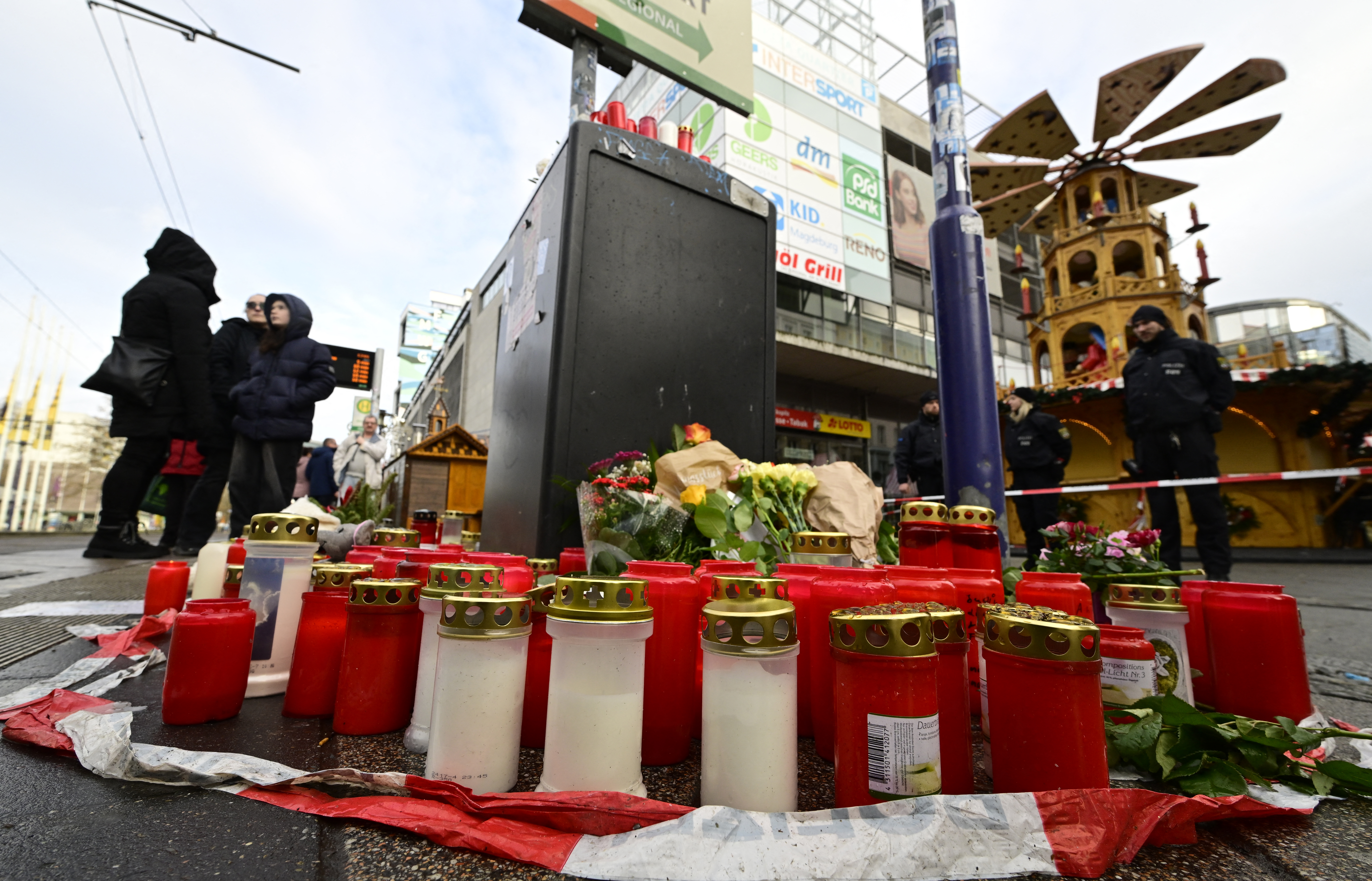 Candles stand at a makeshift memorial at the site of a car-ramming attack on a Christmas market in Magdeburg, eastern Germany, on December 22, 2024. - The death toll in the attack on December 20, rose to 5 on December 21, 2024, with over 200 injured, according to the head of the regional government, Reiner Haseloff. (Photo by John MACDOUGALL / AFP)