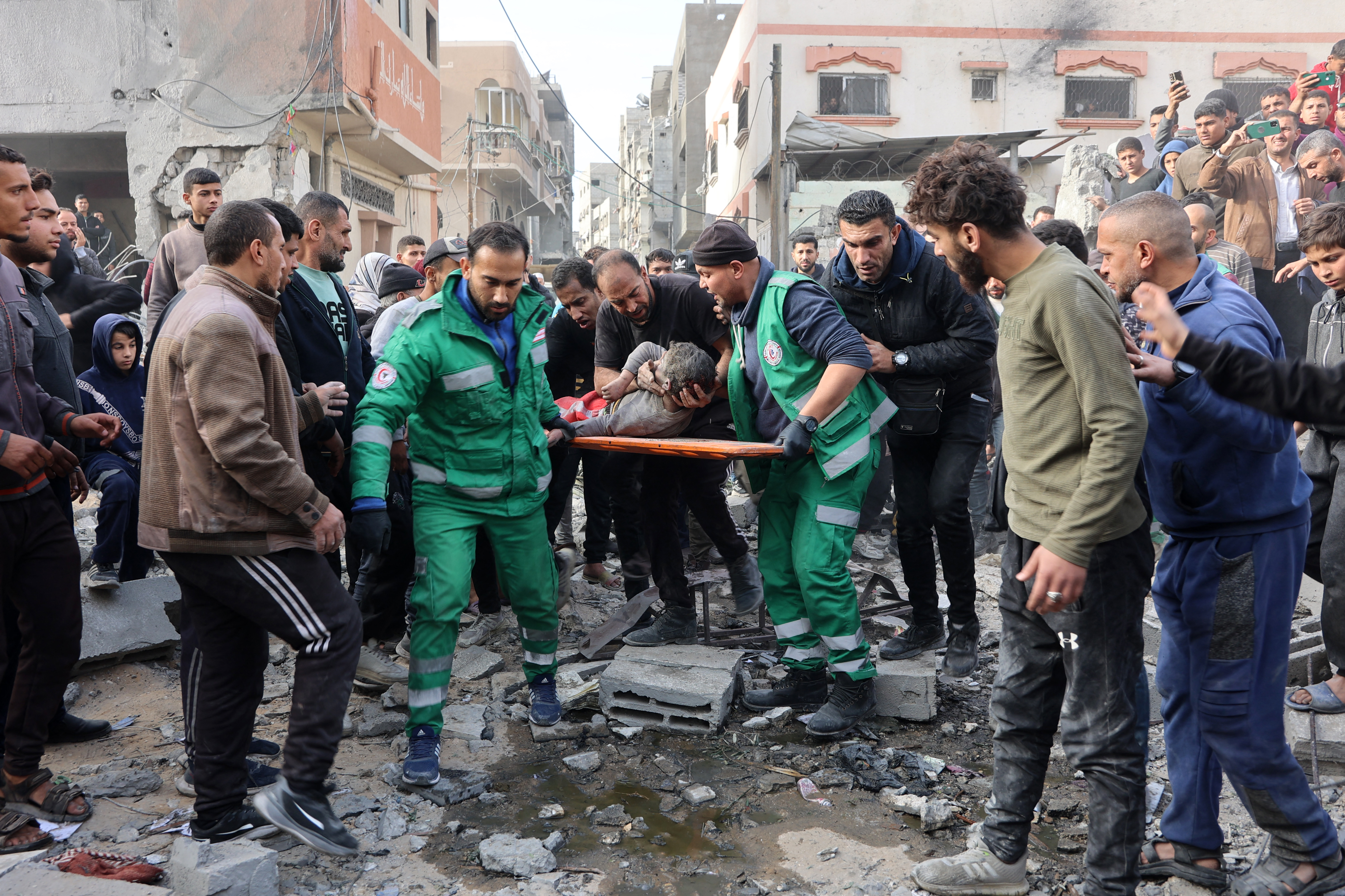 Rescuers evacuate a wounded child at the site of an Israeli strike in a residential area in the Tuffah neighbourhood, east of Gaza City, on December 26