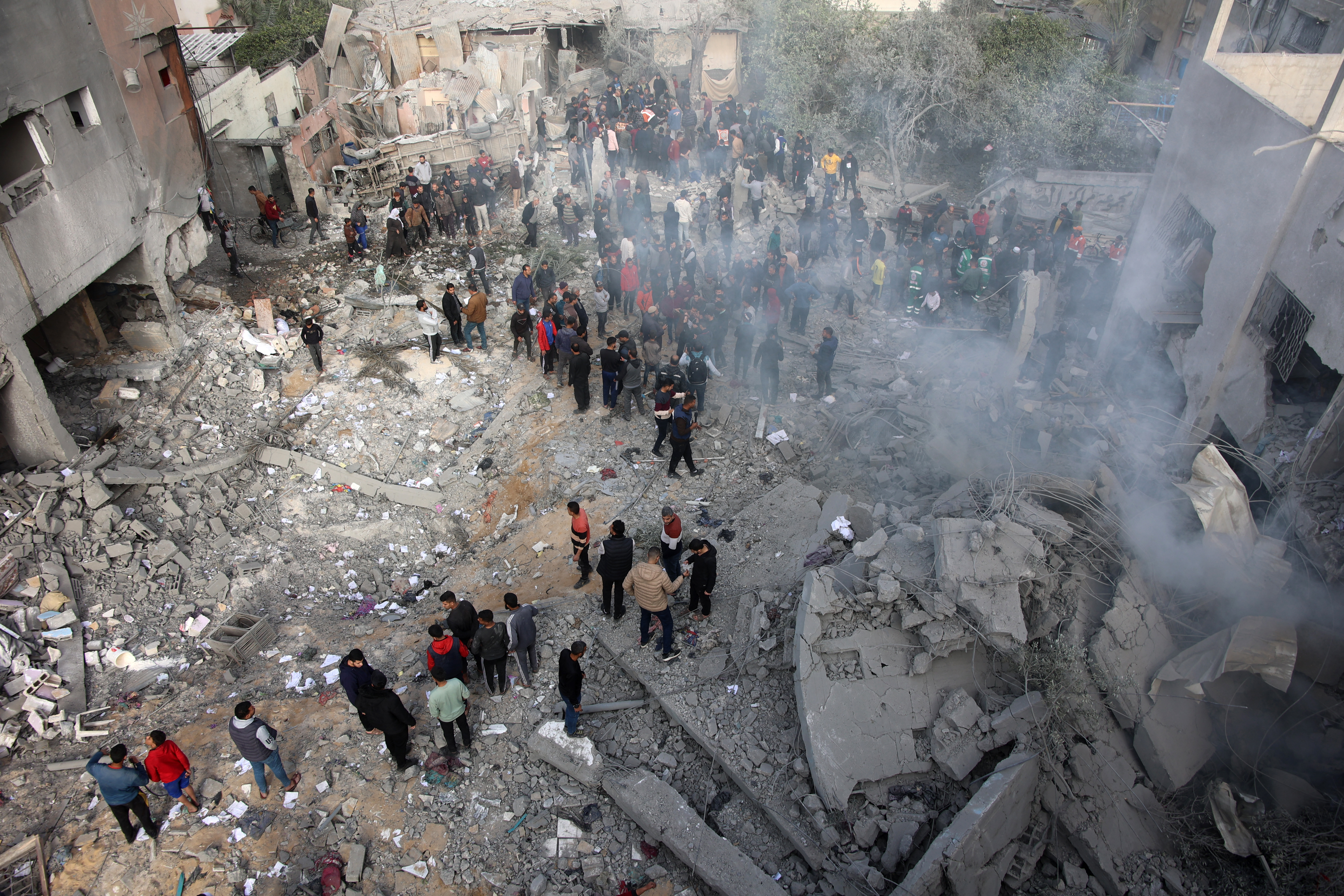 Civilians check the site of an Israeli strike in a residential area at Tuffah neighbourhood, east of Gaza City, on December 26