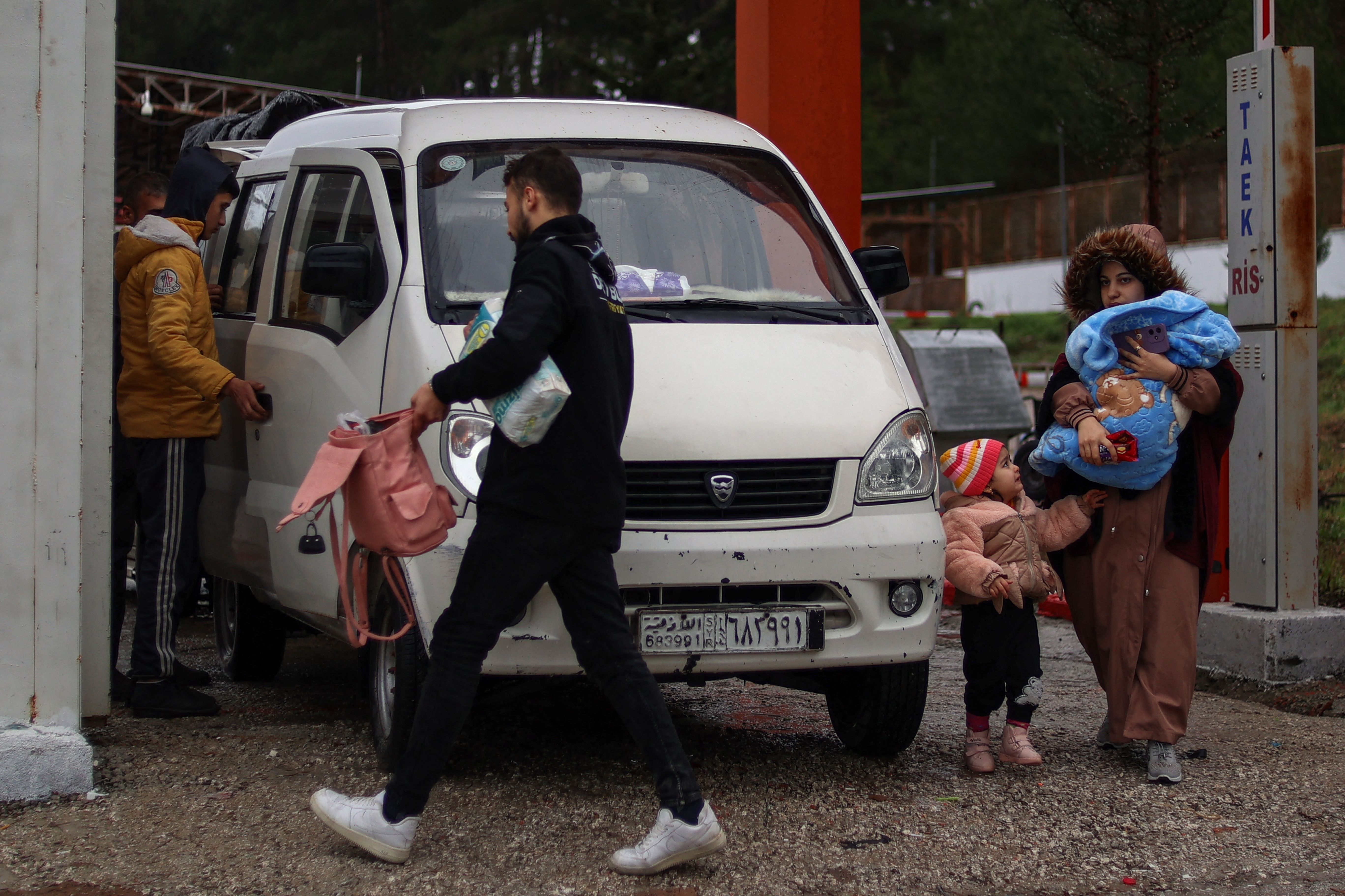 A Syrian family prepares to cross over into Syria from Turkey through the Kassab crossing on December 27, 2024