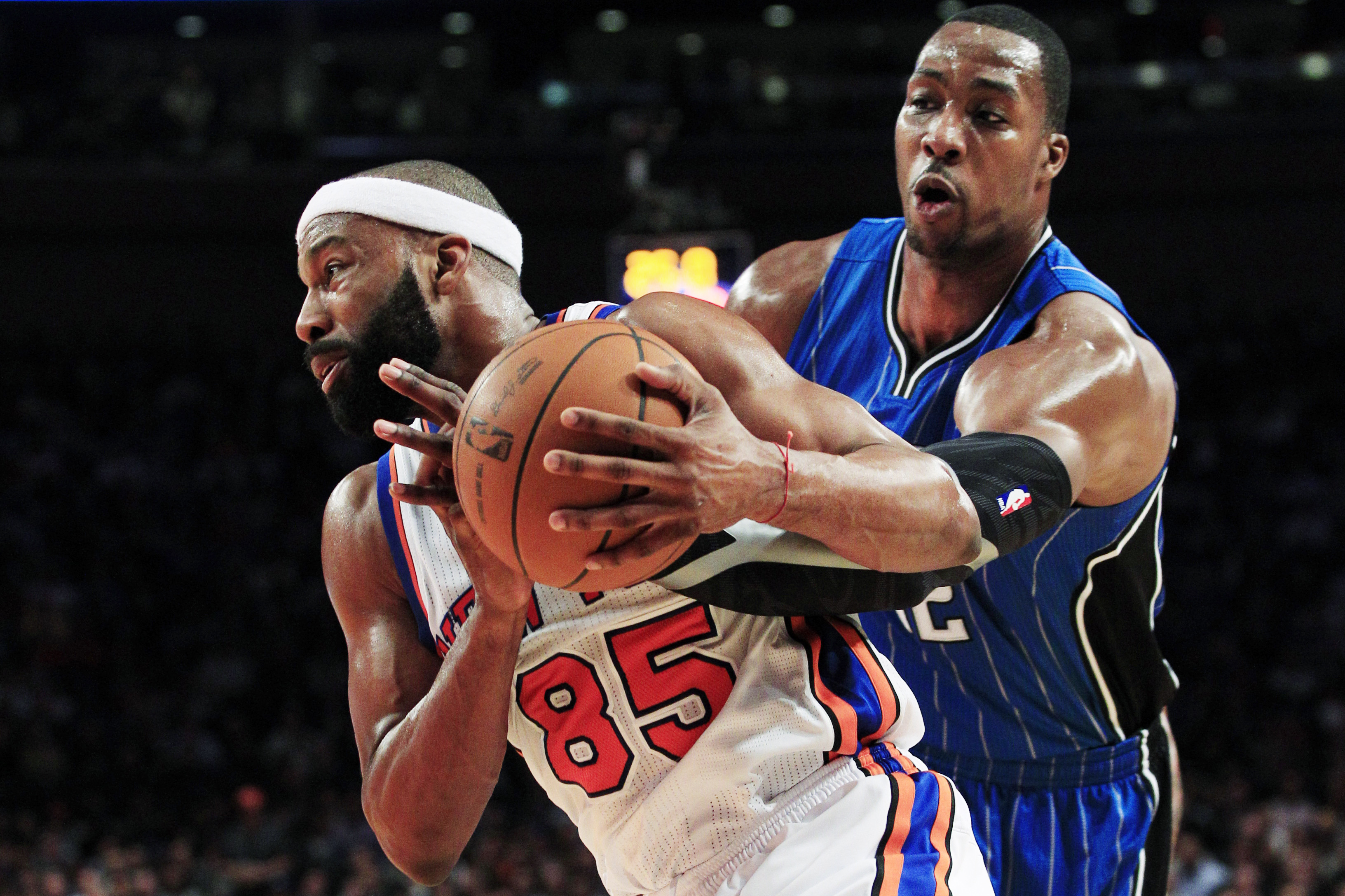 Baron Davis for the New York Knicks tries to move a basketball past Dwight Howard, a player for the Orlando Magic.